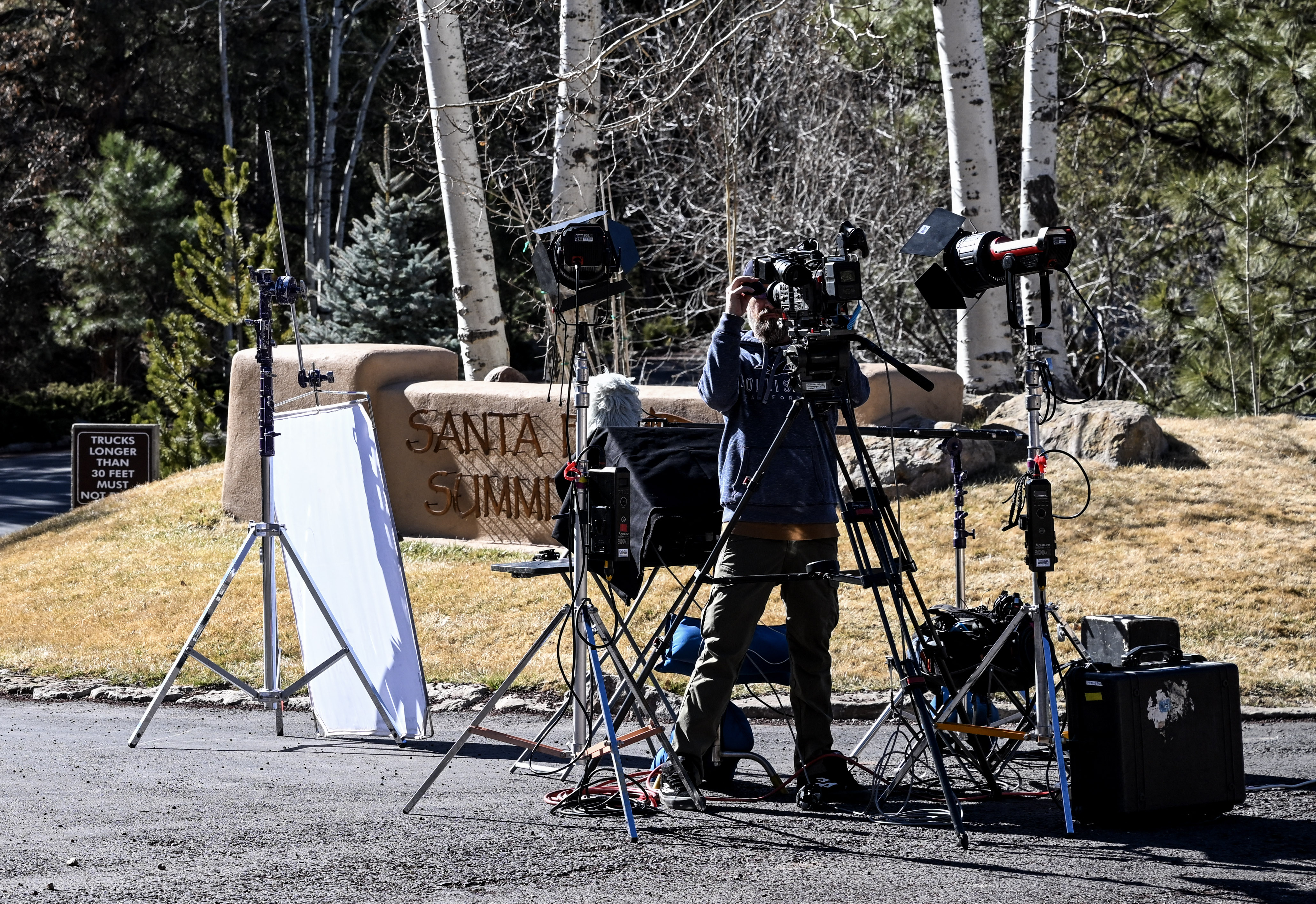 A journalist sets up a camera at the entrance to the Santa Fe Summit neighborhood where late actor Gene Hackman lived, in Santa Fe, New Mexico, on February 28, 2025 | Source: Getty Images