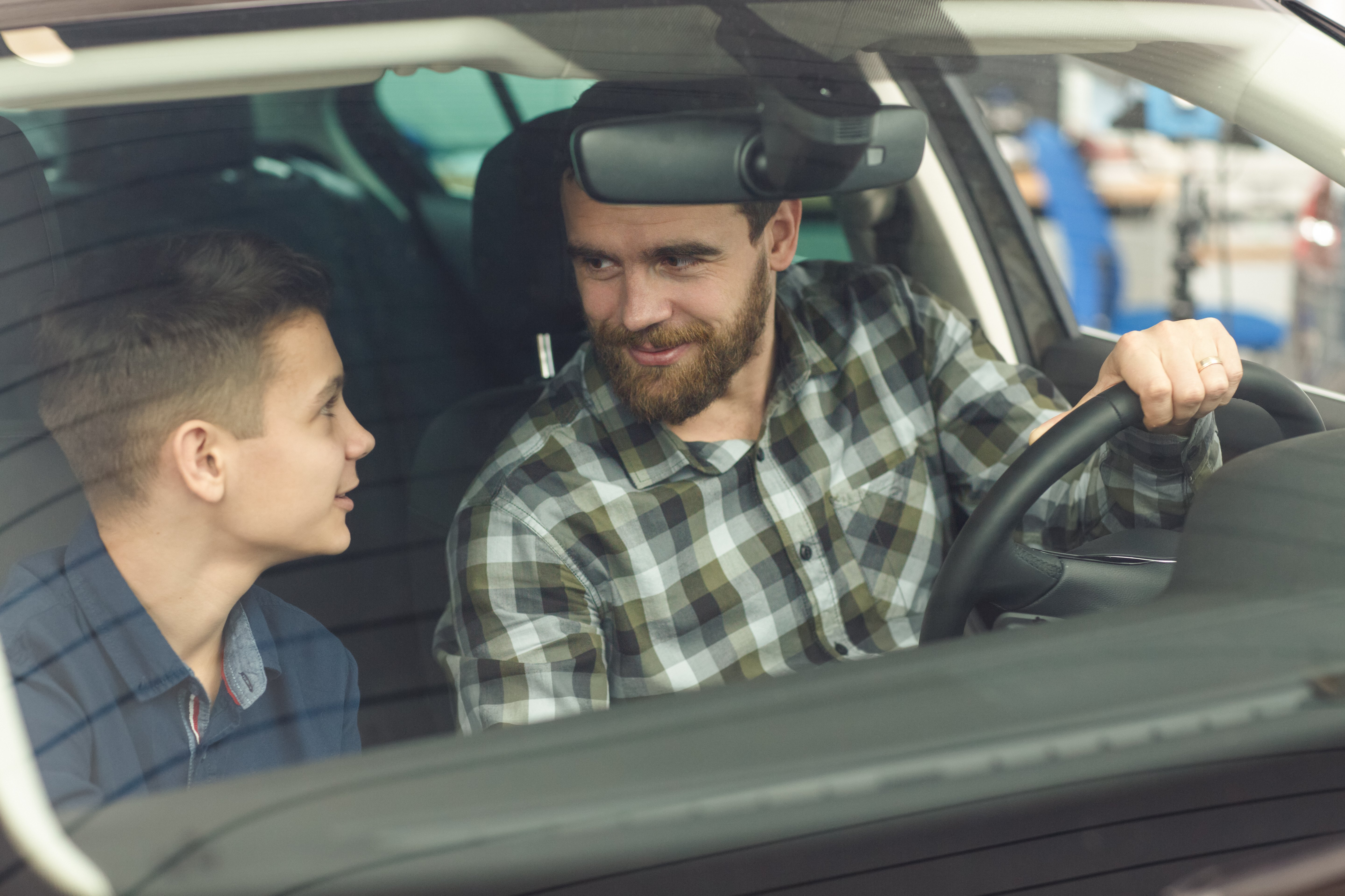 Padre e hijo hablando en el auto. | Foto: Shutterstock