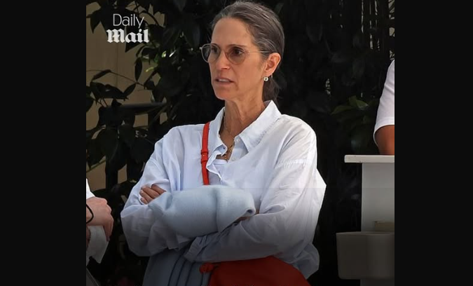 Dressed in a crisp white shirt and glasses, Jami Gertz appeared relaxed yet attentive during a casual daytime conversation outdoors. | Source: Facebook/DailyMailEntertainment