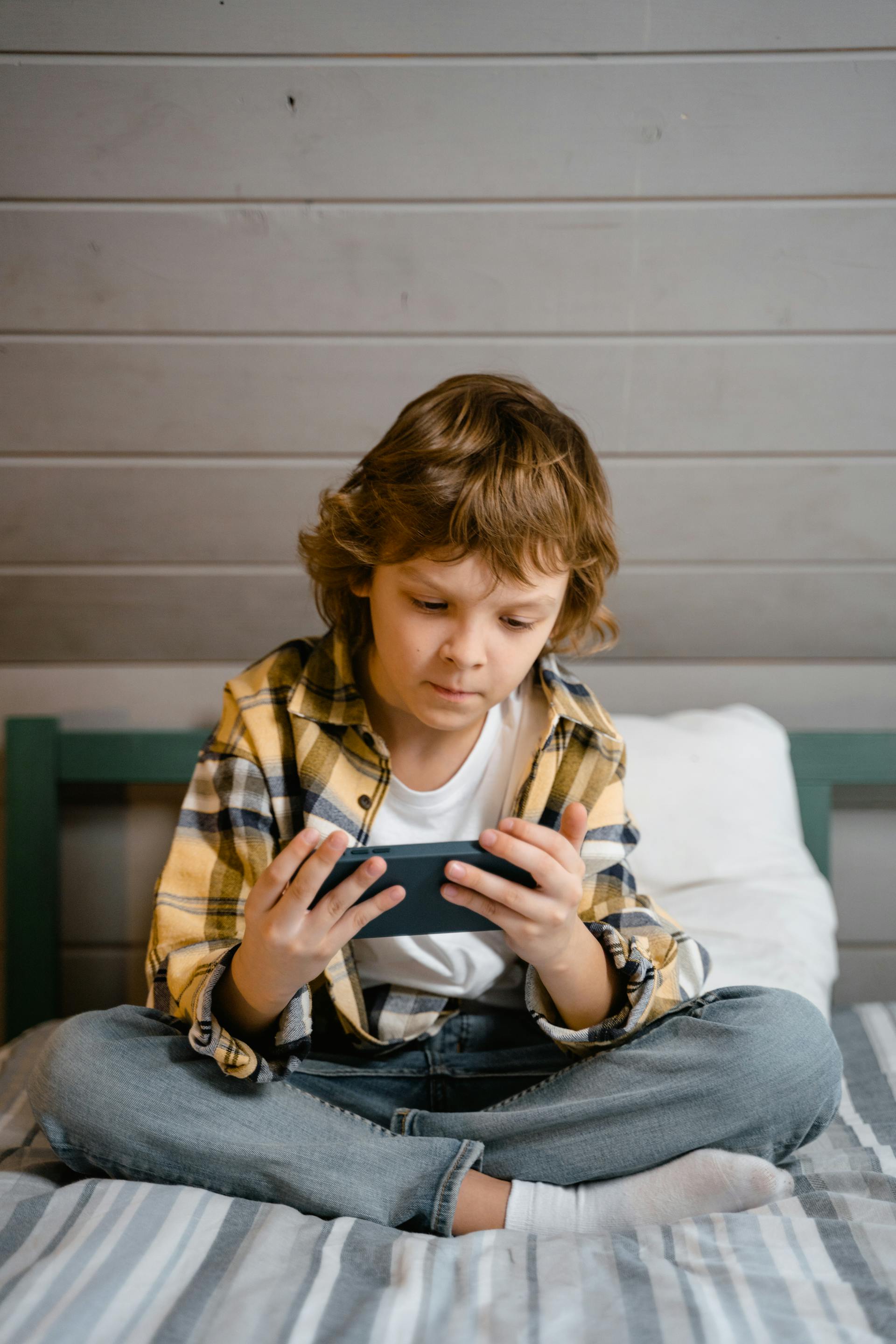 A little boy sitting on the bed | Source: Pexels