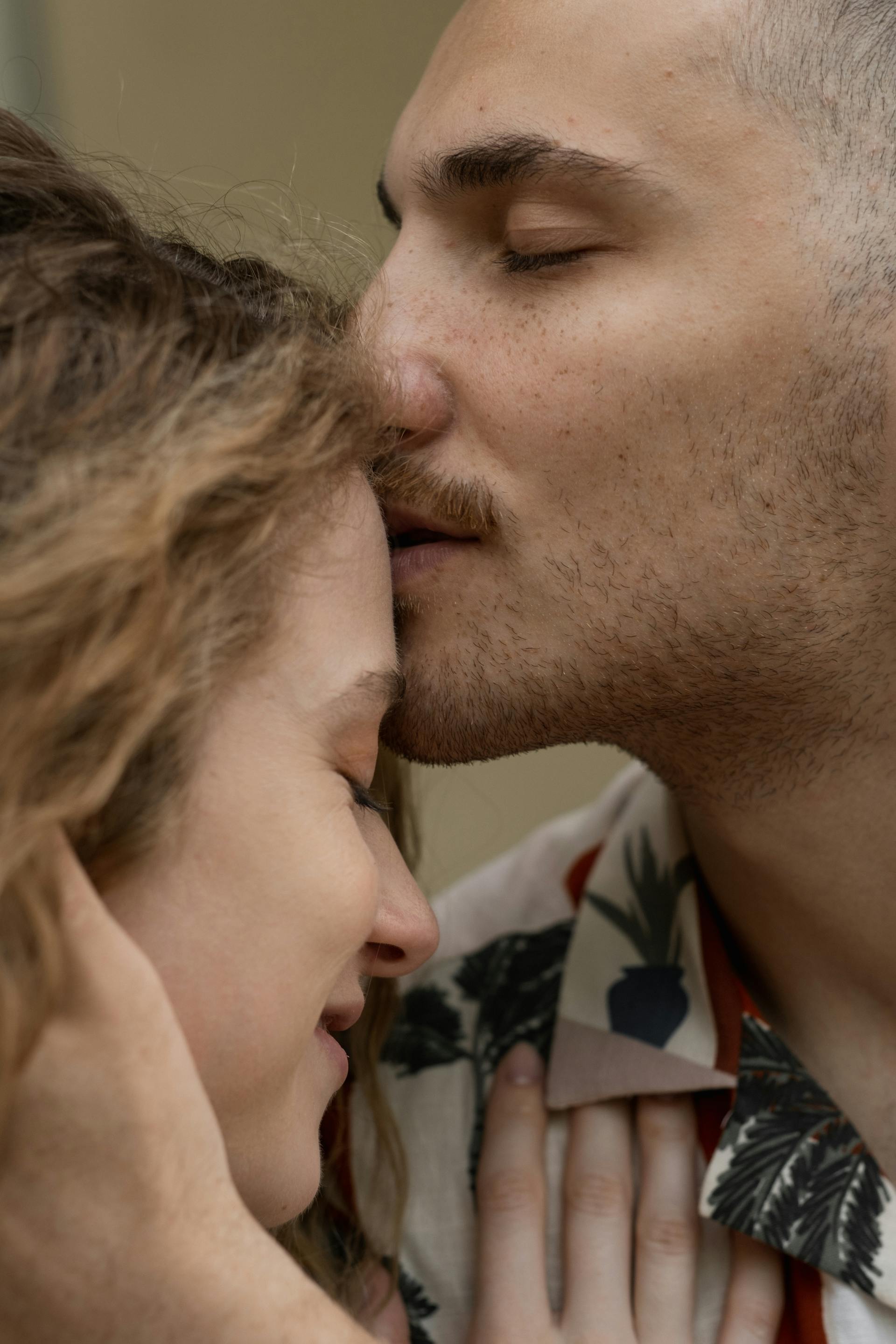 A man kisses his wife on the forehead | Source: Pexels
