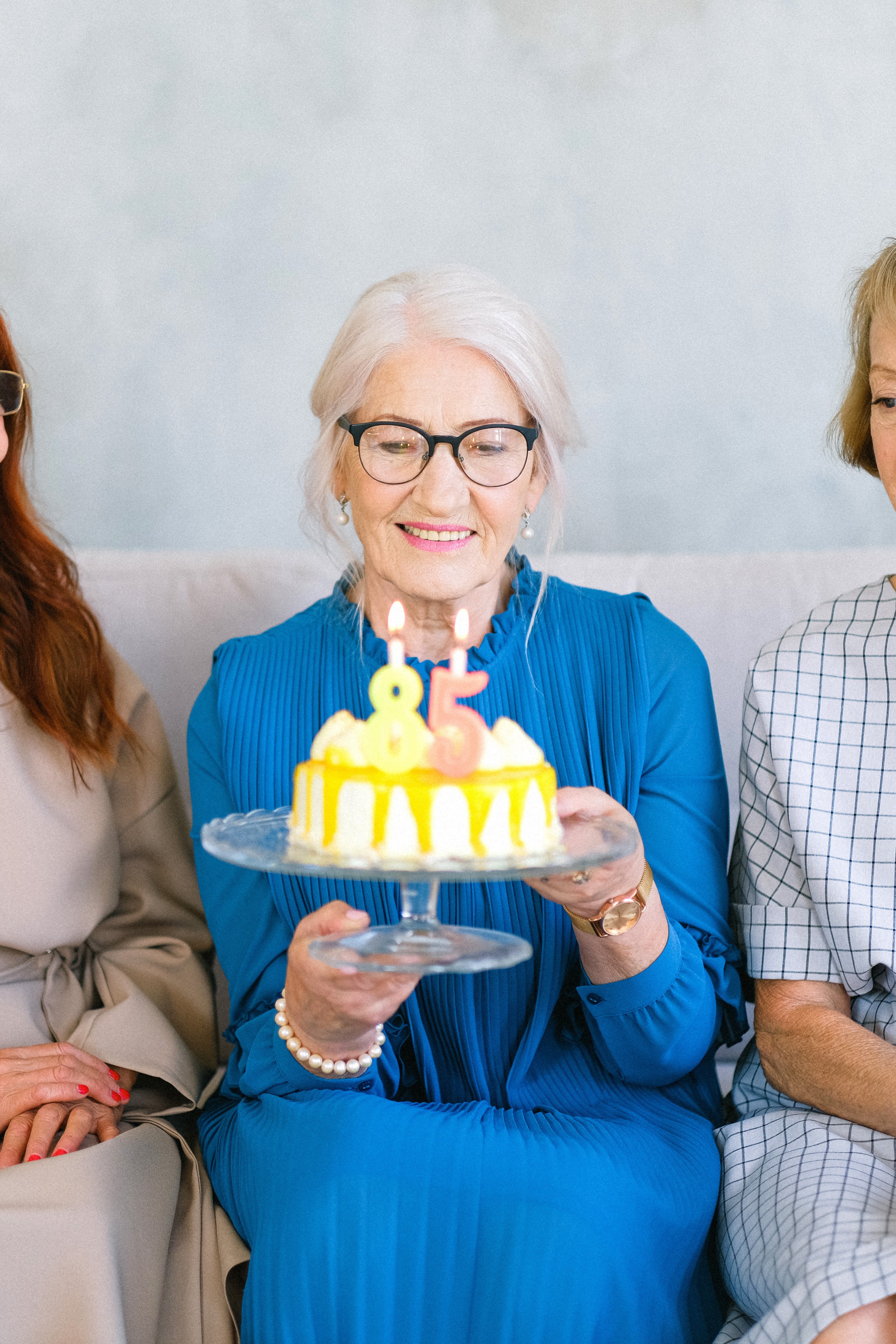 Una anciana con un pastel de cumpleaños en sus manos. | Foto: Pexels
