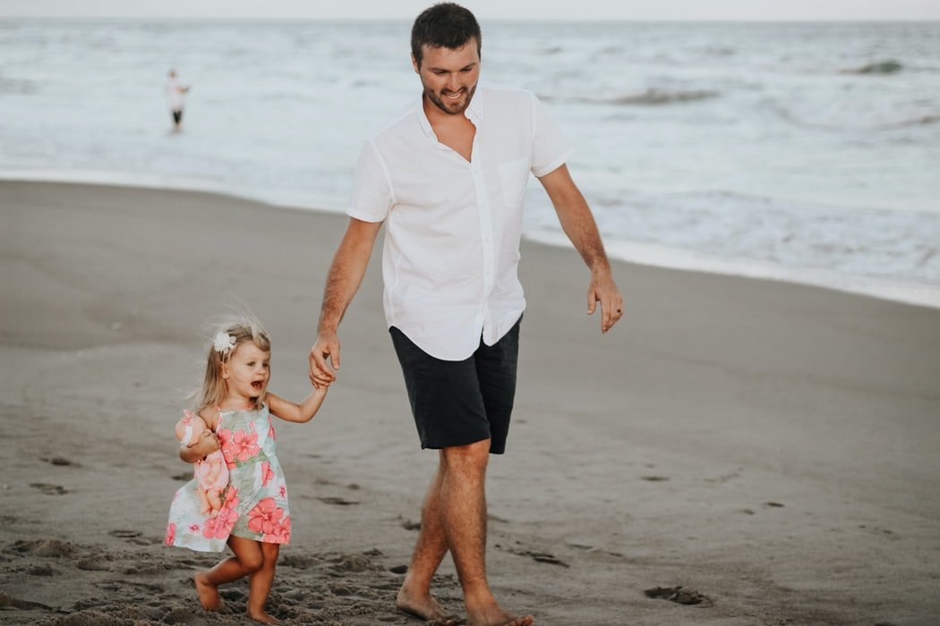Padre e hija caminando en la playa. | Foto: Unsplash