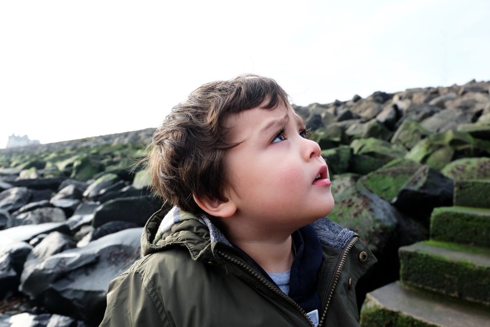Un petit garçon fronçant les sourcils en regardant vers le ciel | Photo: Shutterstock