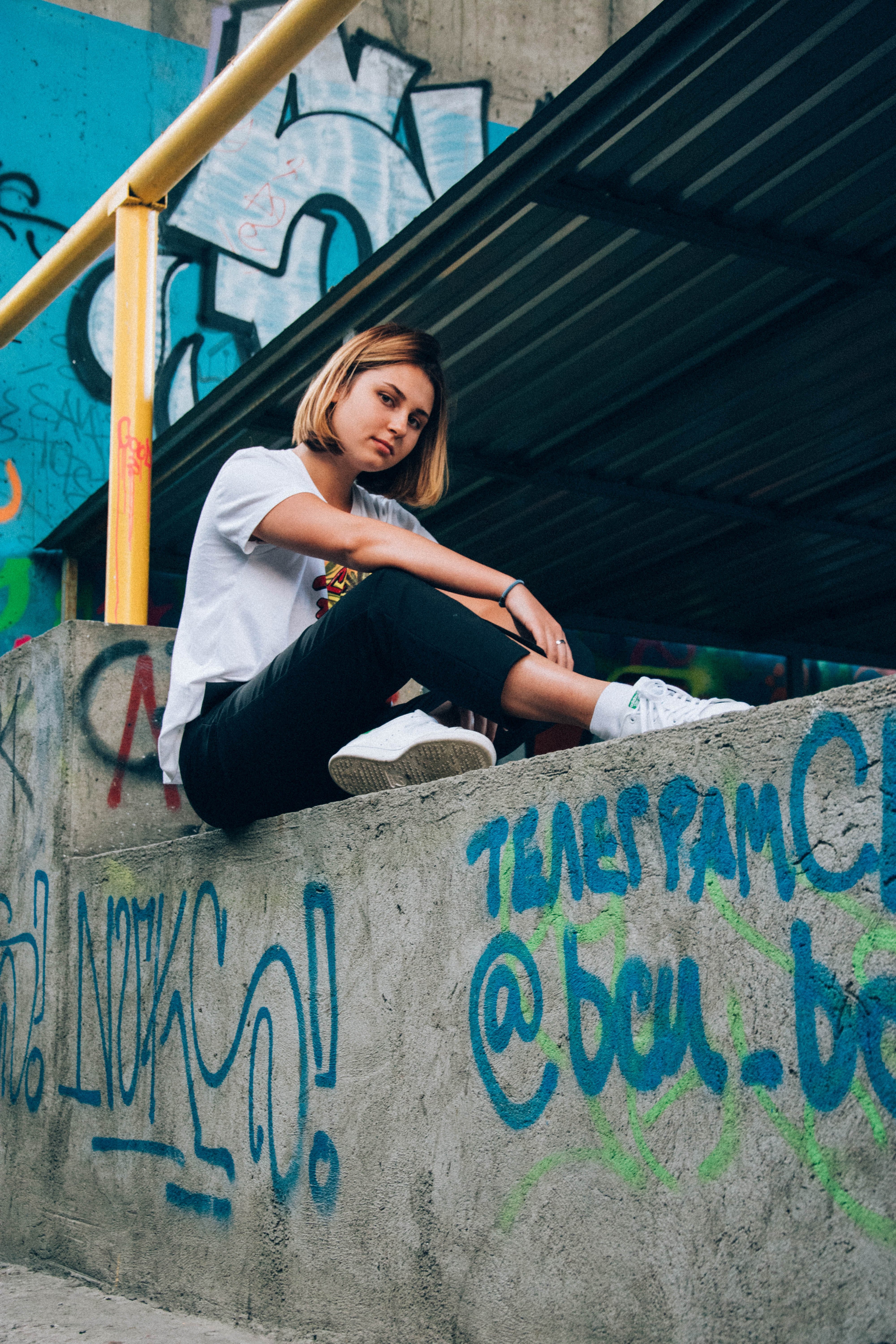 A young woman sitting on a wall. | Source: Unsplash