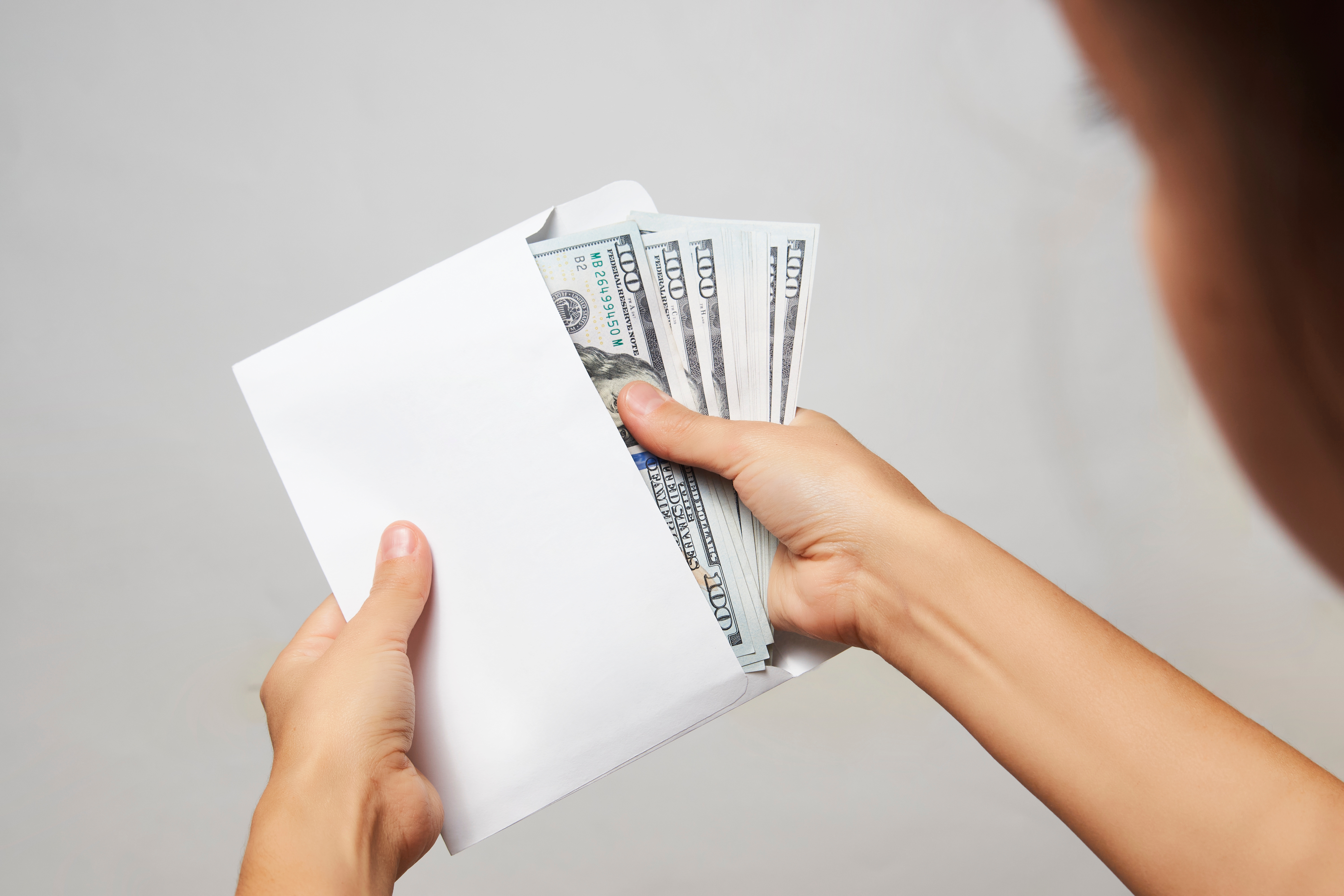 Woman takes the money out of the envelope | Source: Shutterstock.com
