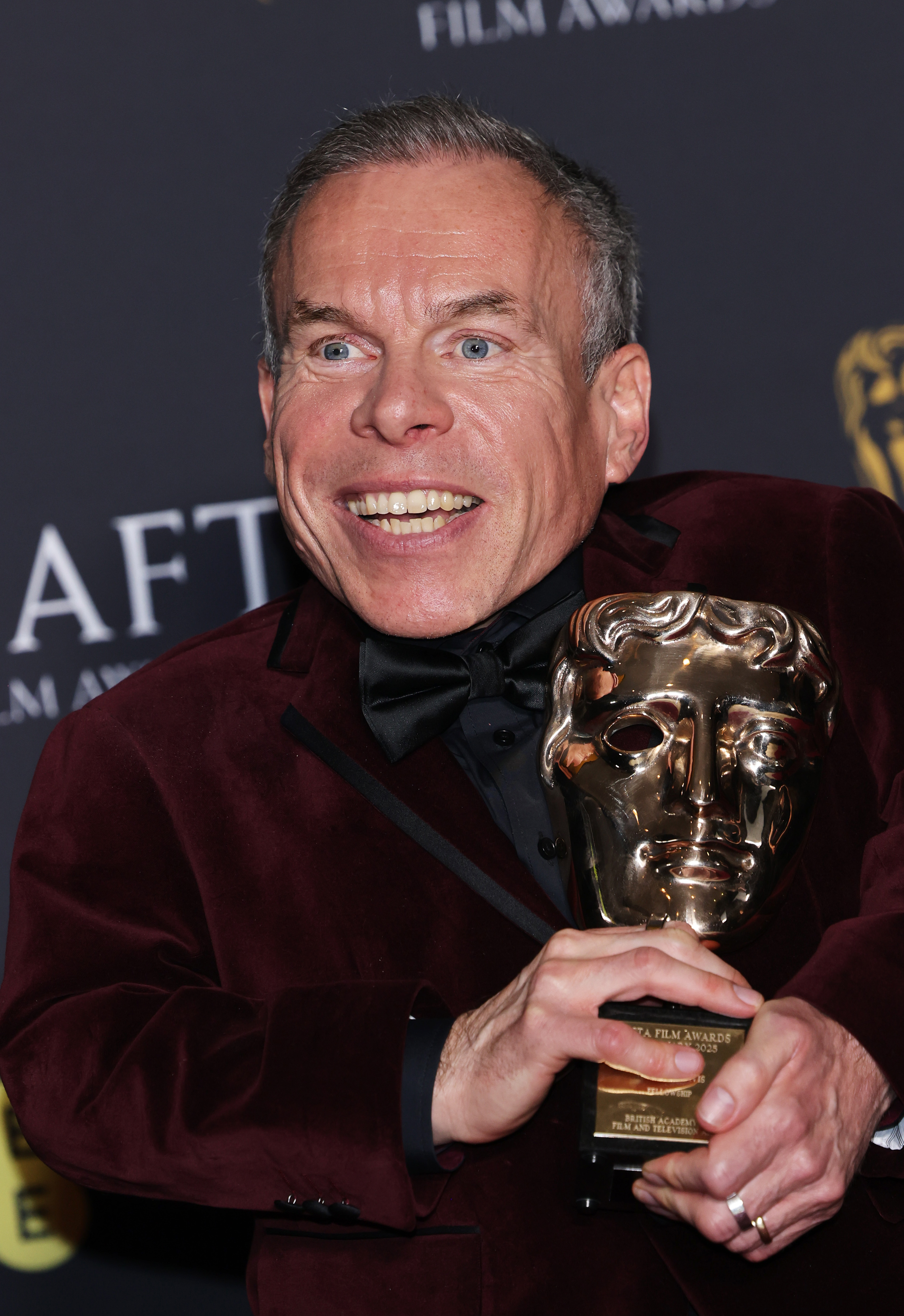 Warwick Davis poses with his award on February 16, 2025 | Source: Getty Images