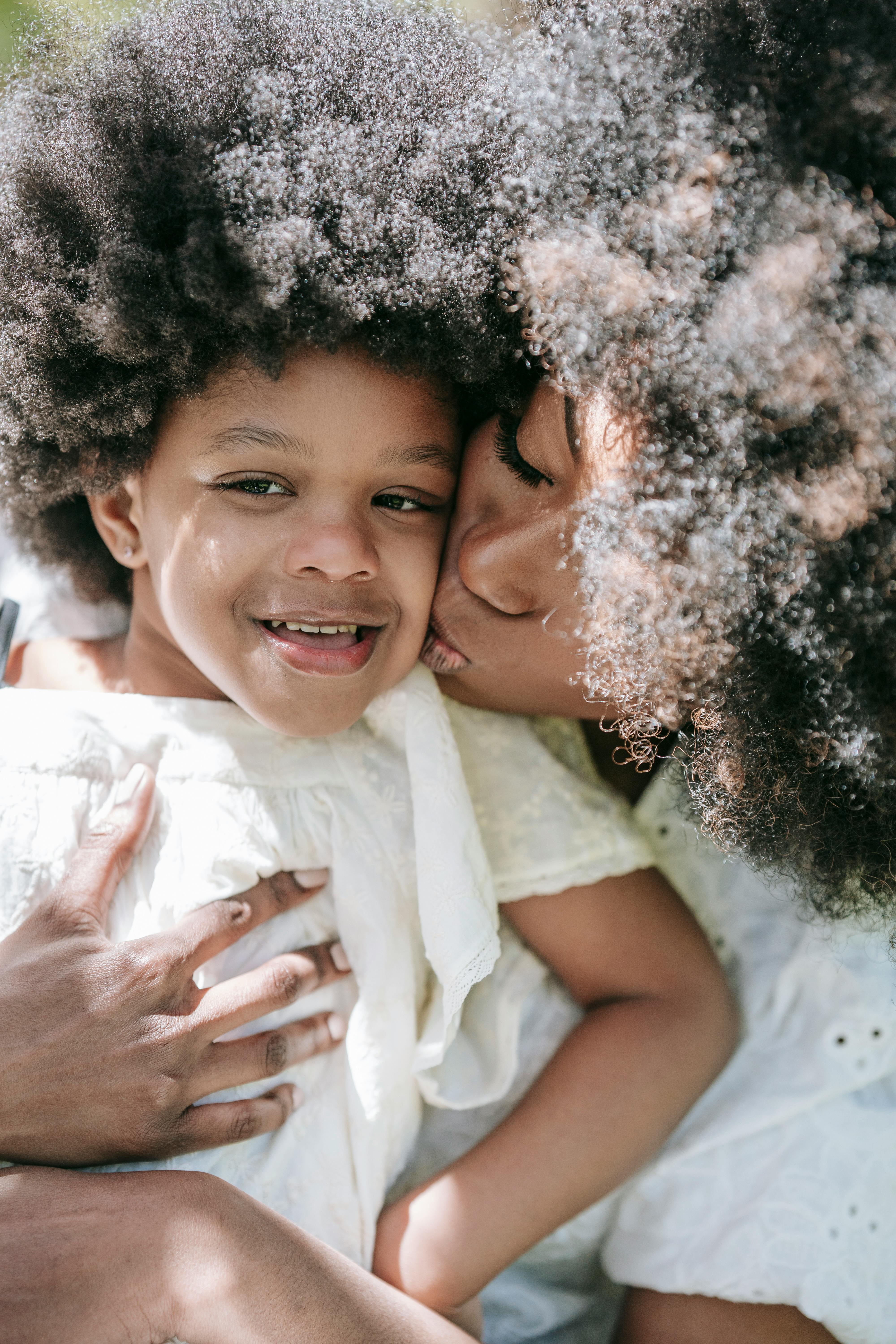 A woman kissing her daughter | Source: Pexels