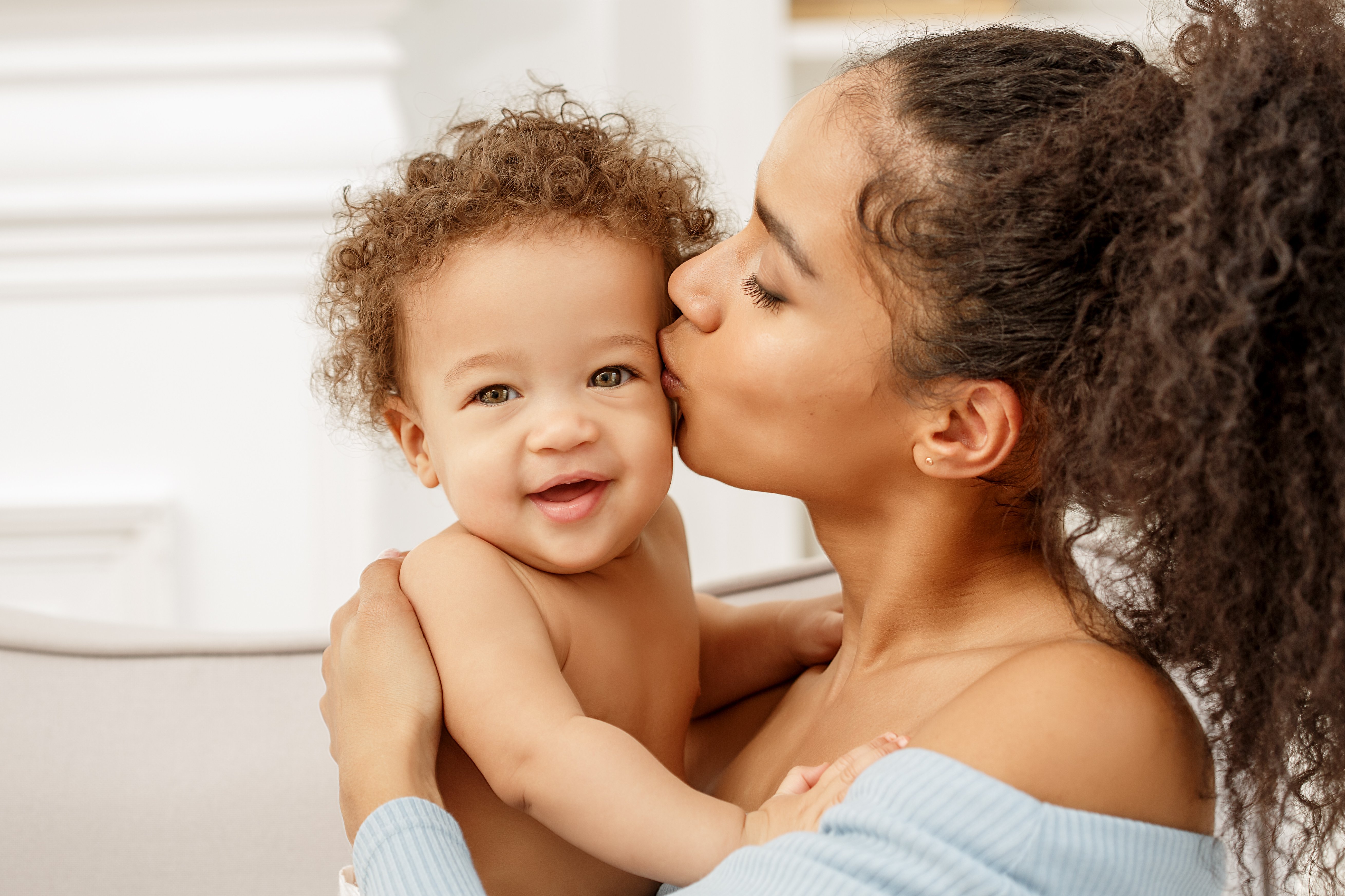 Una madre besando a su bebé en la mejilla. | Foto: Shutterstock