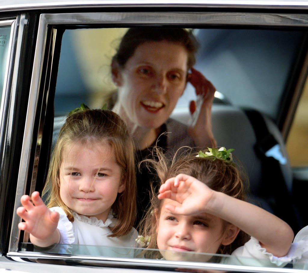 La princesse Charlotte de Cambridge et Theodora Williams (accompagnées de la nounou de la princesse Charlotte, Maria Teresa Turrion Borrallo) assistent au mariage de la princesse Eugénie d'York et de Jack Brooksbank à la chapelle St George le 12 octobre 2018 à Windsor, en Angleterre. І Source : Getty Images