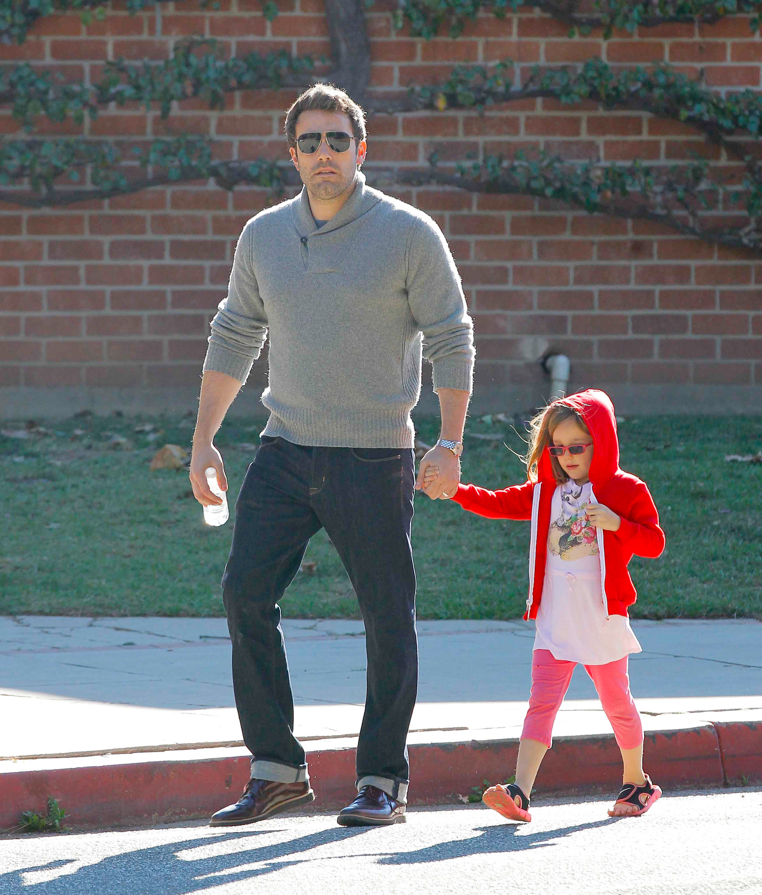 Ben Affleck carries a young Seraphina Affleck—now known as Fin—while out in Brentwood, California, on Decembe r. 23, 2012. The image captures an early father-and-child moment years before Fin's recent public appearances attracted renewed attention. | Source: Getty Images