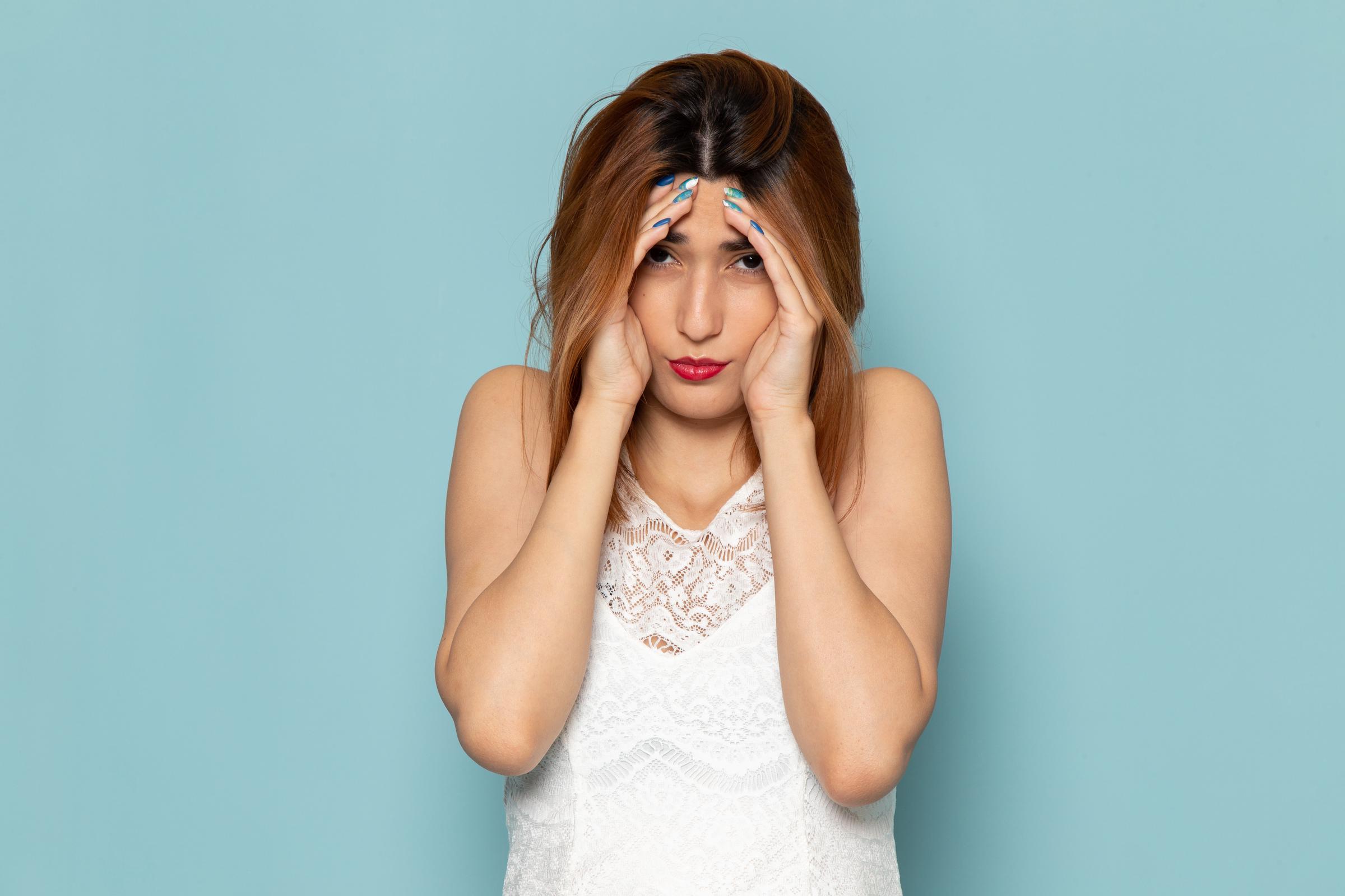 A shocked woman hiding her face | Source: Freepik