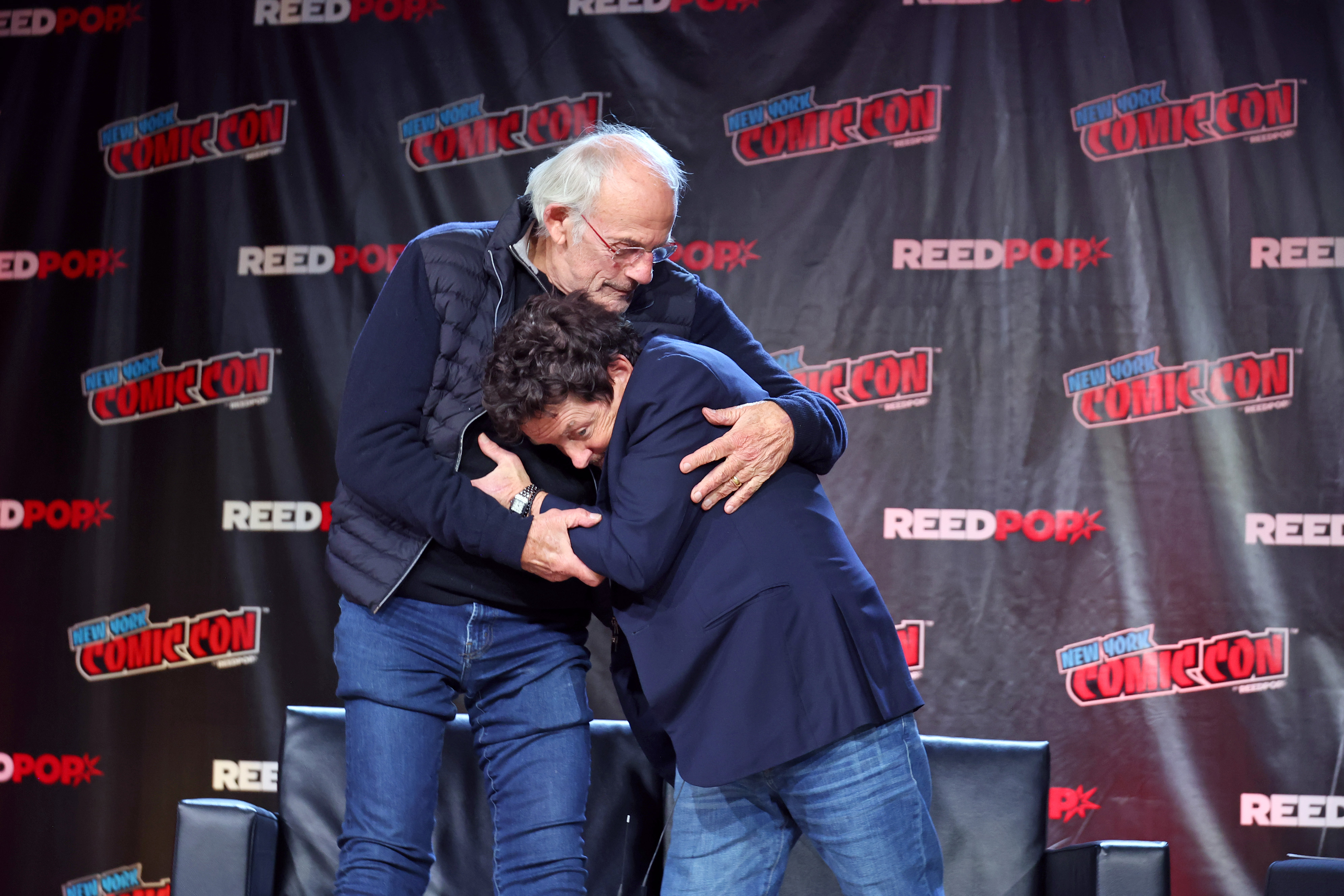 Christopher Lloyd and Michael J. Fox embrace during "Back To The Future Reunion" on October 8, 2022 in New York City | Source: Getty Images