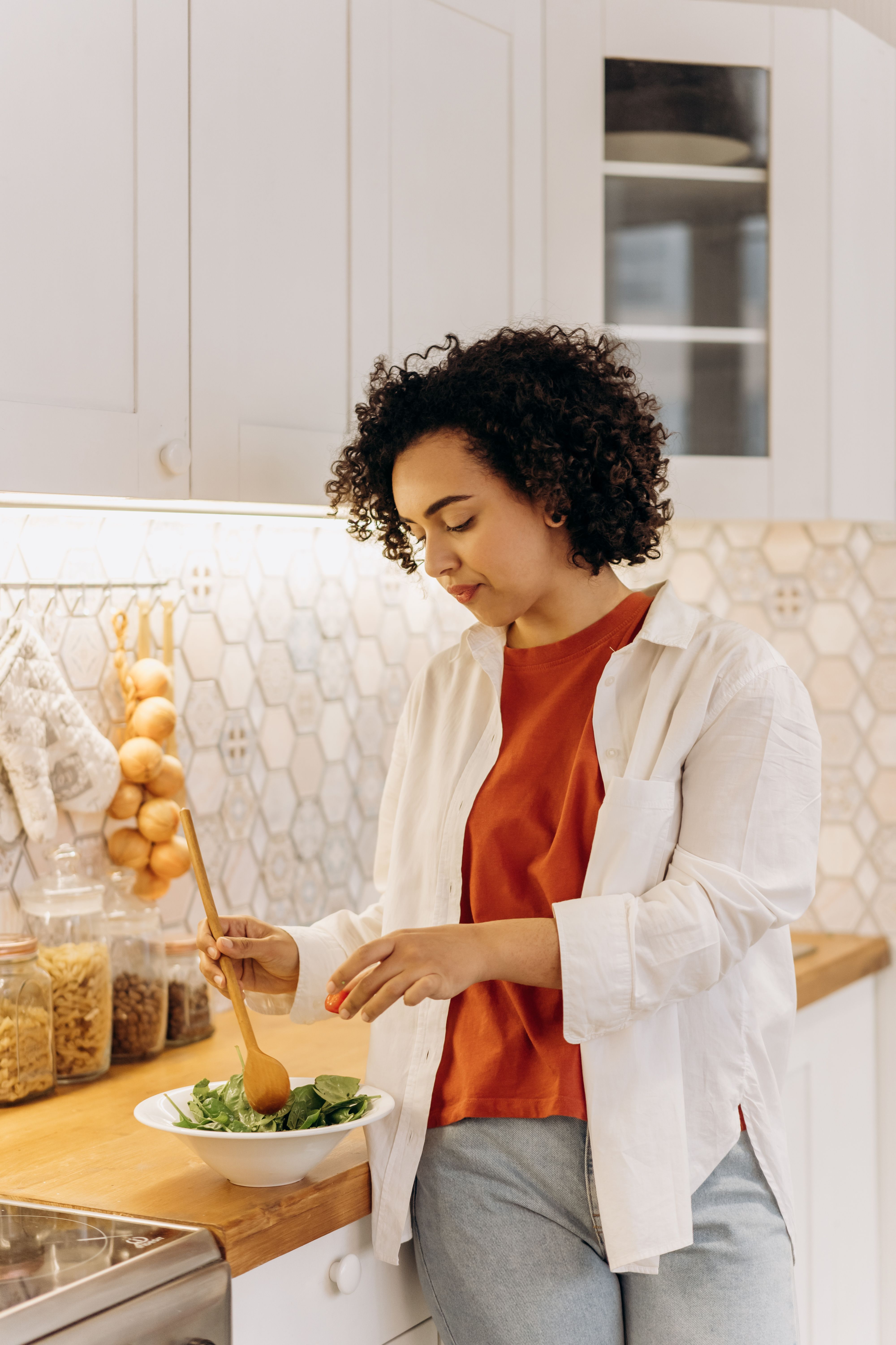 A woman preparing a salad dish | Source: Pexels