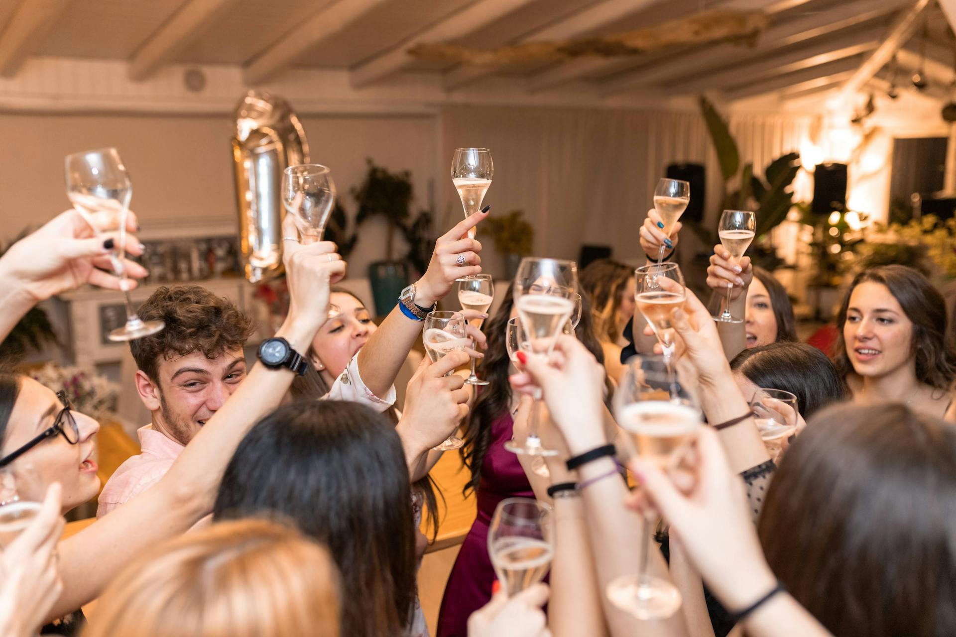Young men and women raising their glasses of drink in a restaurant | Source: Pexels