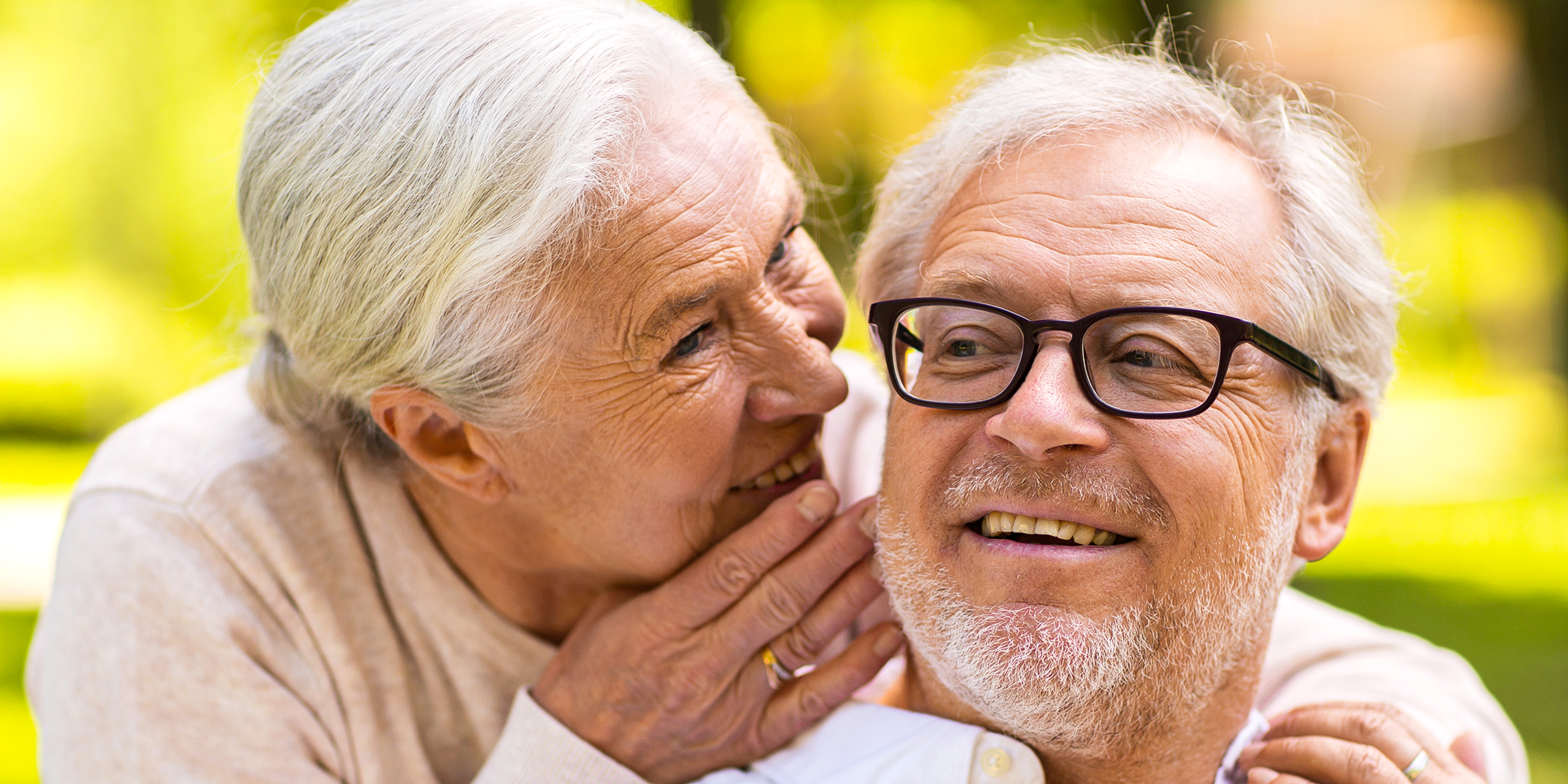 An elderly woman whispering to her husband | Source: Shutterstock