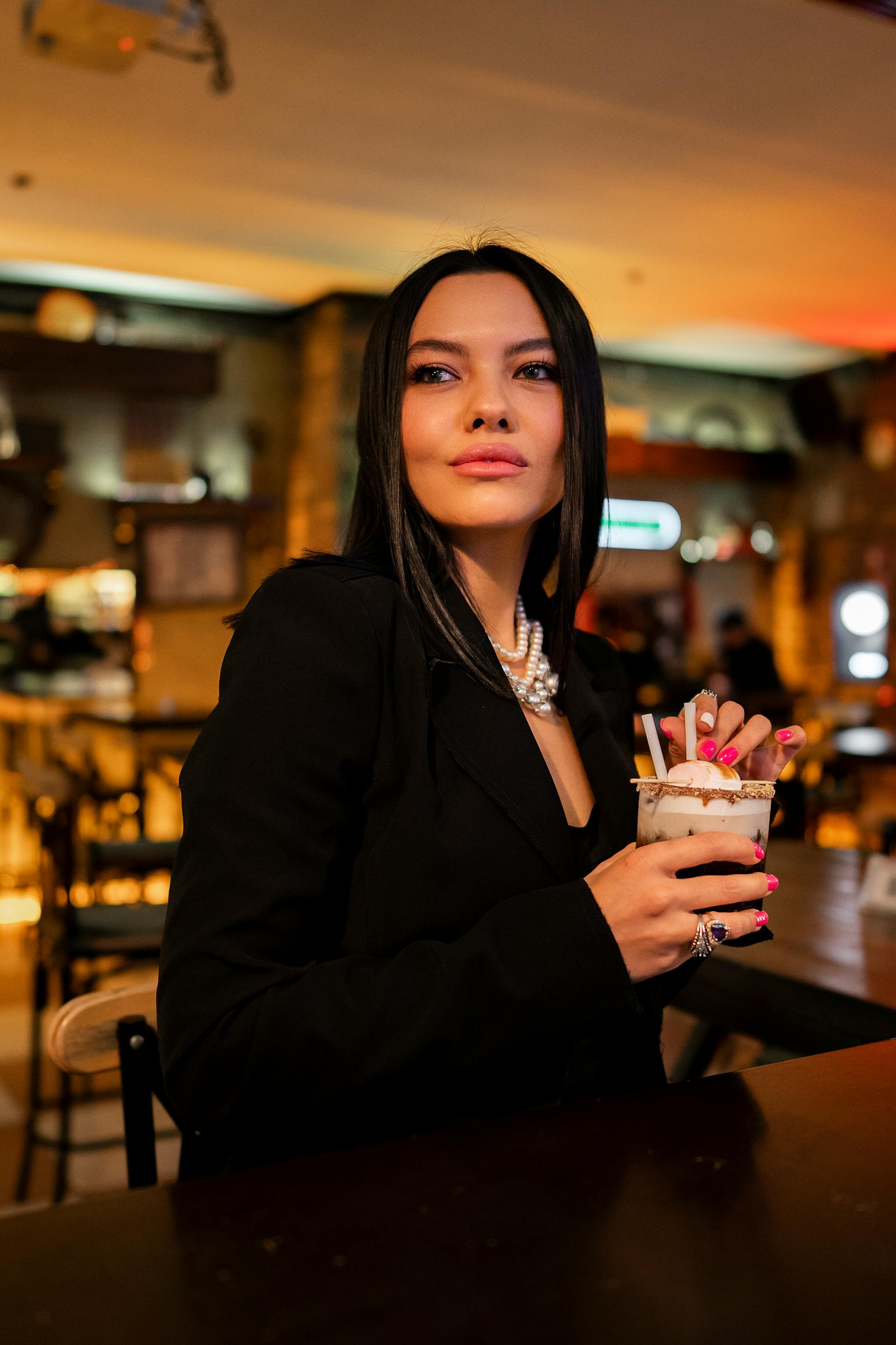 A woman with a cocktail standing in a bar | Source: Pexels