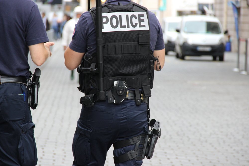 The back of a police officer, who is wearing a protective vest. | Photo: Shutterstock