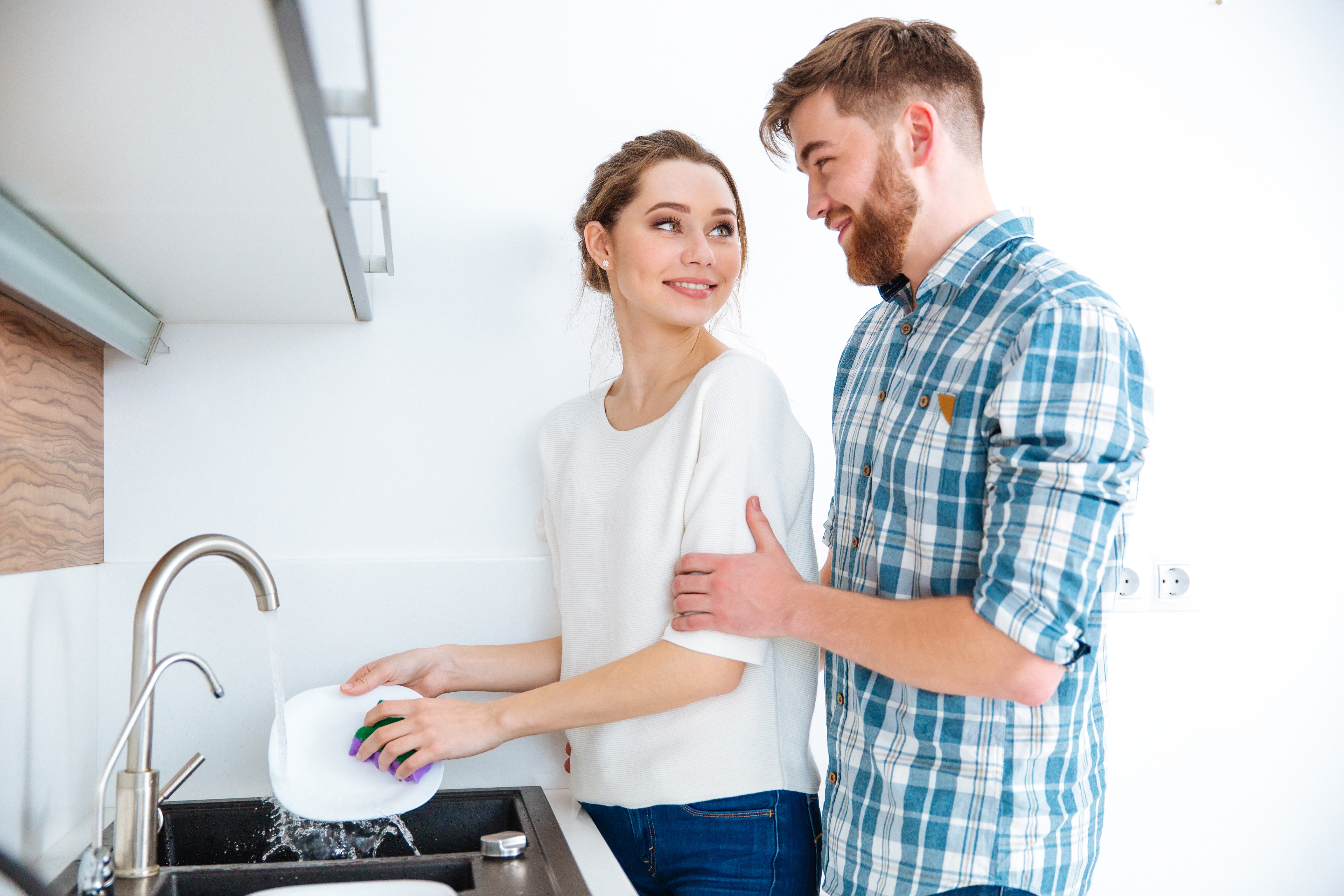 A husband helping his wife in the kitchen | Source: Shutterstock
