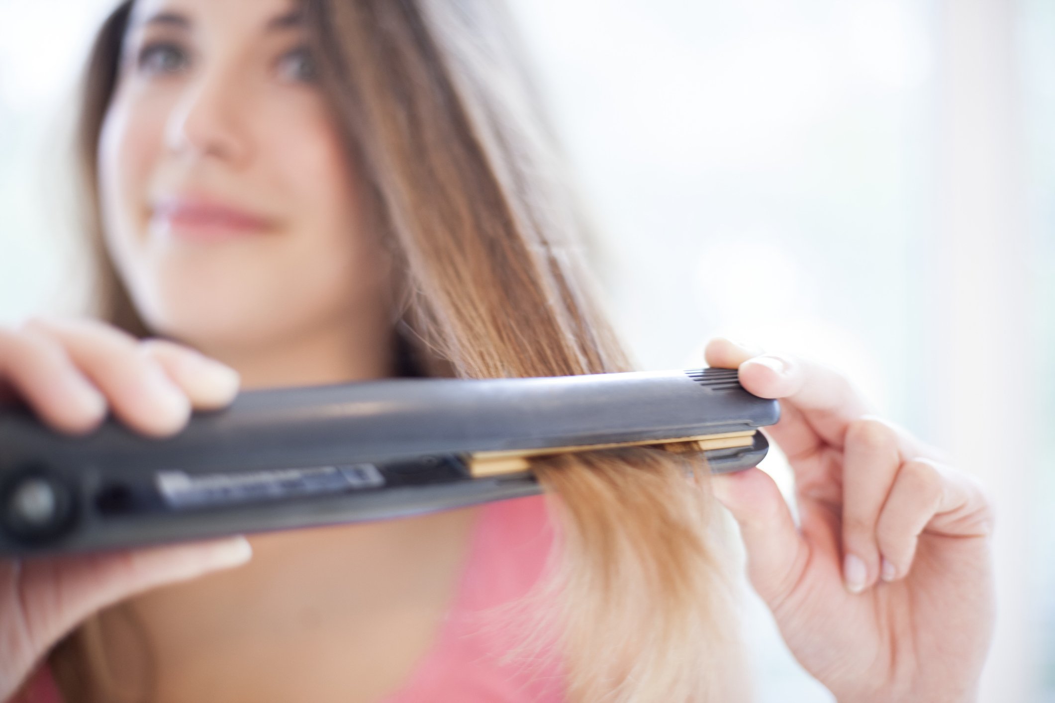 Une femme qui lisse ses cheveux. | Photo : Getty Images