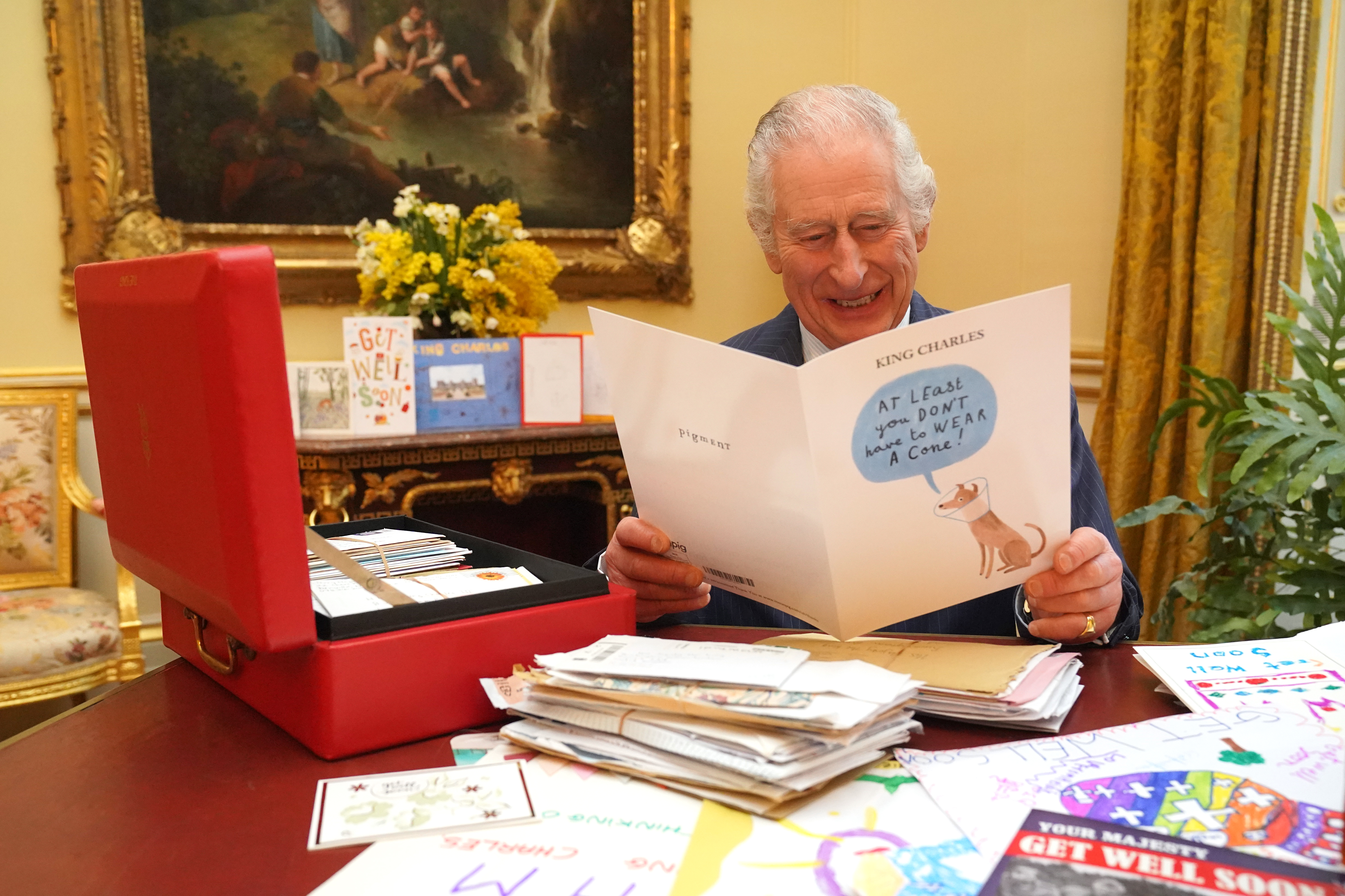 King Charles reading cards sent by well-wishers following his cancer diagnosis, in the 18th Century Room of the Belgian Suite at Buckingham Palace on February 21, 2024 in London, England | Source: Getty Images