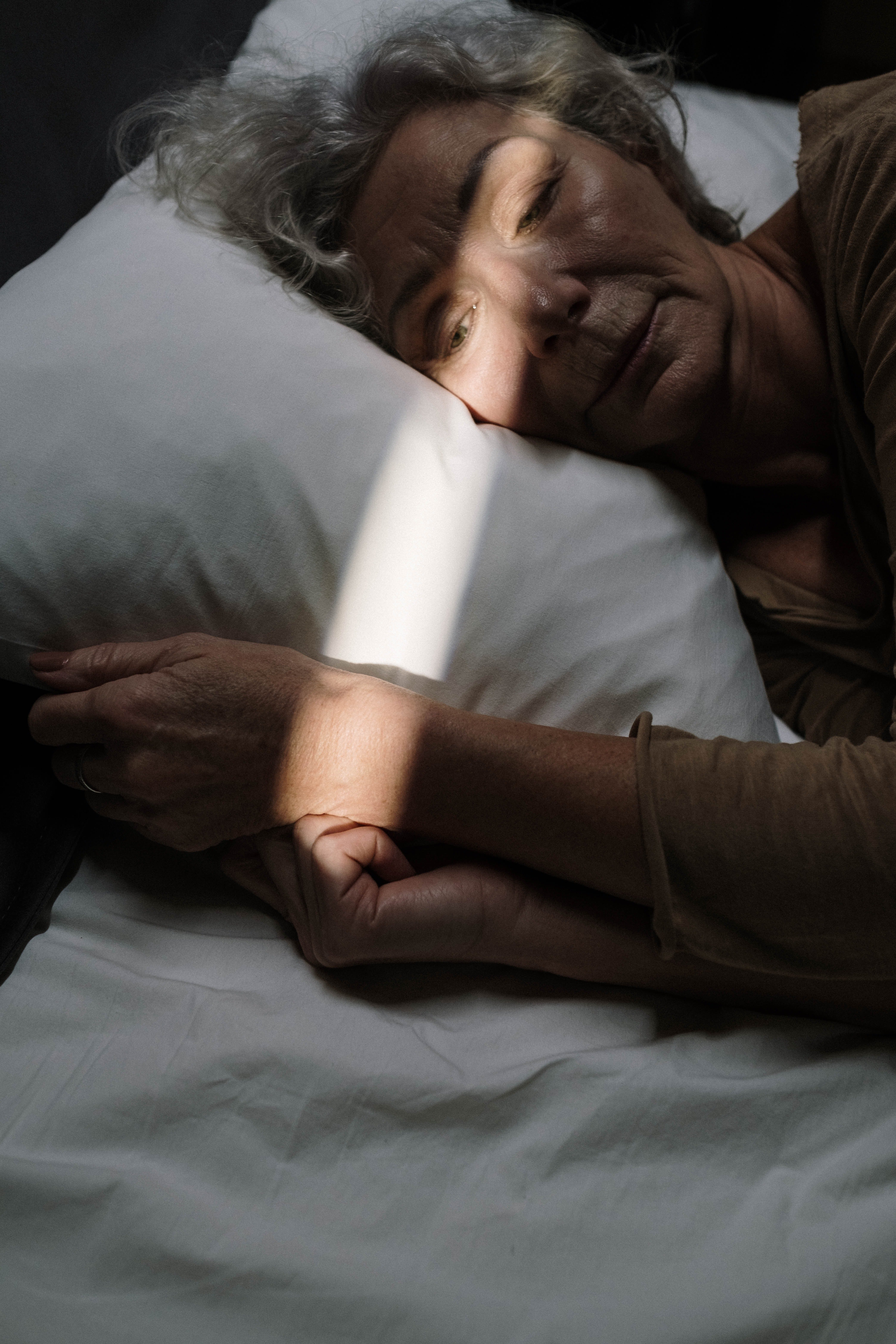 Mujer mayor acostada sobre su almohada. | Foto: Pexels