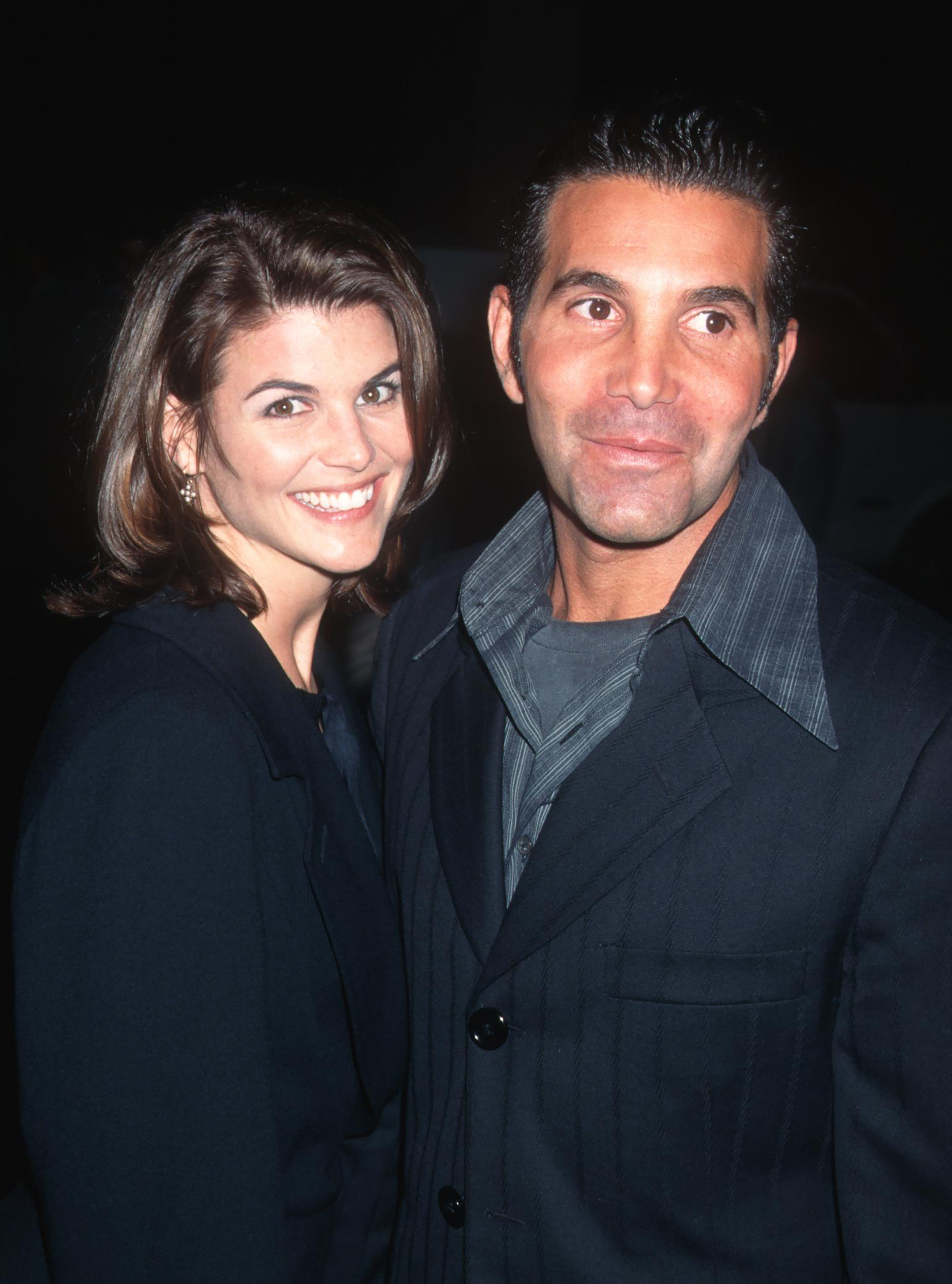 Lori Loughlin and Mossimo Giannulli are pictured at the GQ Magazine cocktail party honoring Peter Bart at the Beverly Hills Hotel in Beverly Hills, California, on December 12, 1995, smiling together for the camera.
