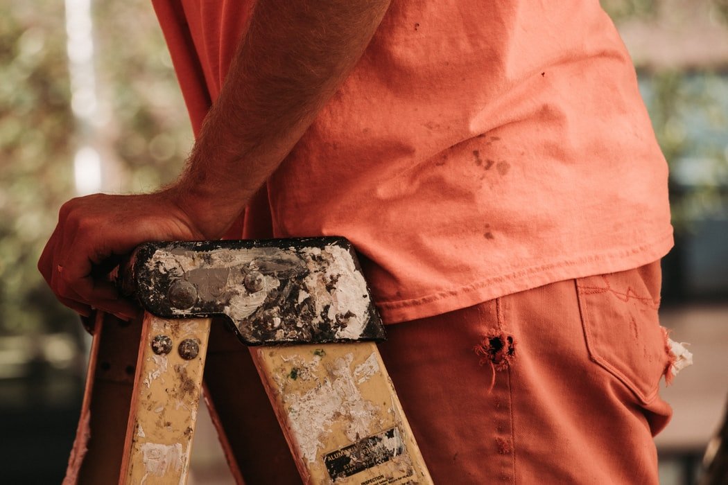 I saw a man out in the yard leaning on a ladder against the side of the house | Source: Unsplash