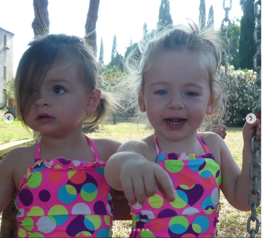 Tabitha and Marion sit on a wooden swing in matching swimsuits in another childhood memory shared by Sarah Jessica Parker on Instagram. | Source: Instagram/sarahjessicaparker