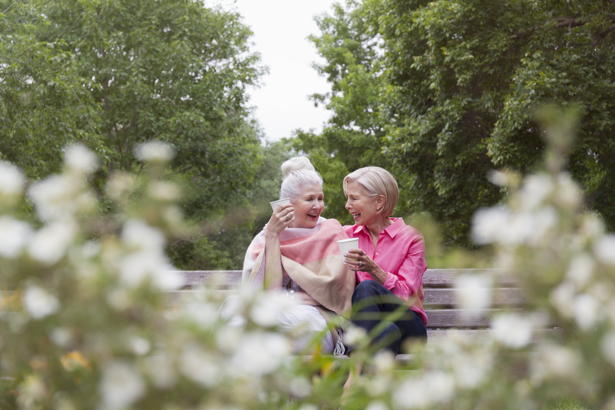Zwei ältere Frauen trinken zusammen Kaffee im Park. I Quelle: Getty Images