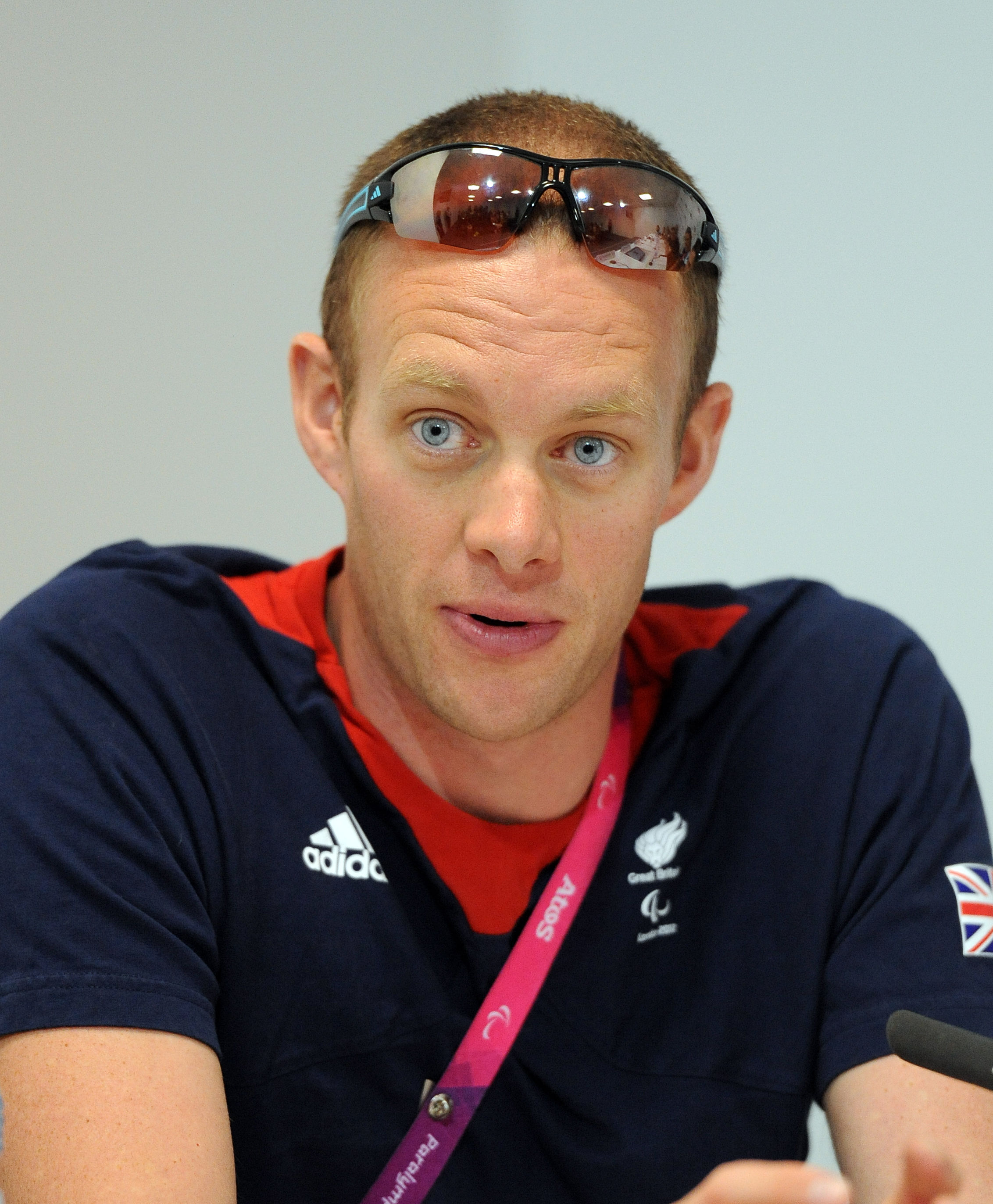 Composed and Courageous: David Smith leans forward with quiet intensity during a ParalympicsGB press conference on 9 September 2012 in London. Clad in his Team GB attire with sunglasses perched atop his head, the gold medallist appears focused and resolute as he reflects on the journey that made him a national hero.