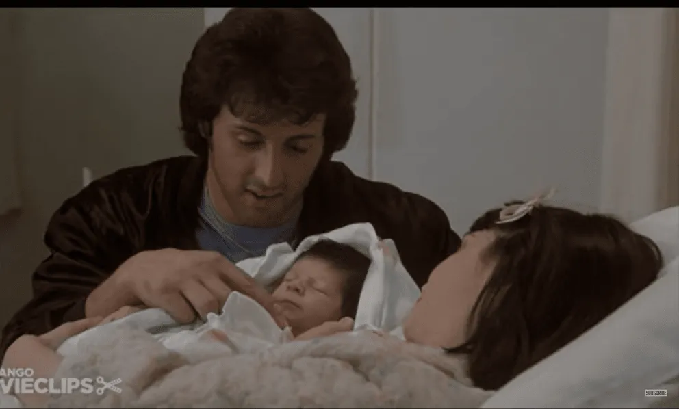 Sylvester Stallone en tant que Rocky Balboa, Seargeoh Stallone en tant que Robert 'Rocky' Jr. et Talia Shire en tant que (Adrian Pennino) dans le film, "Rocky II" ┃Source : YouTube/@Movieclips