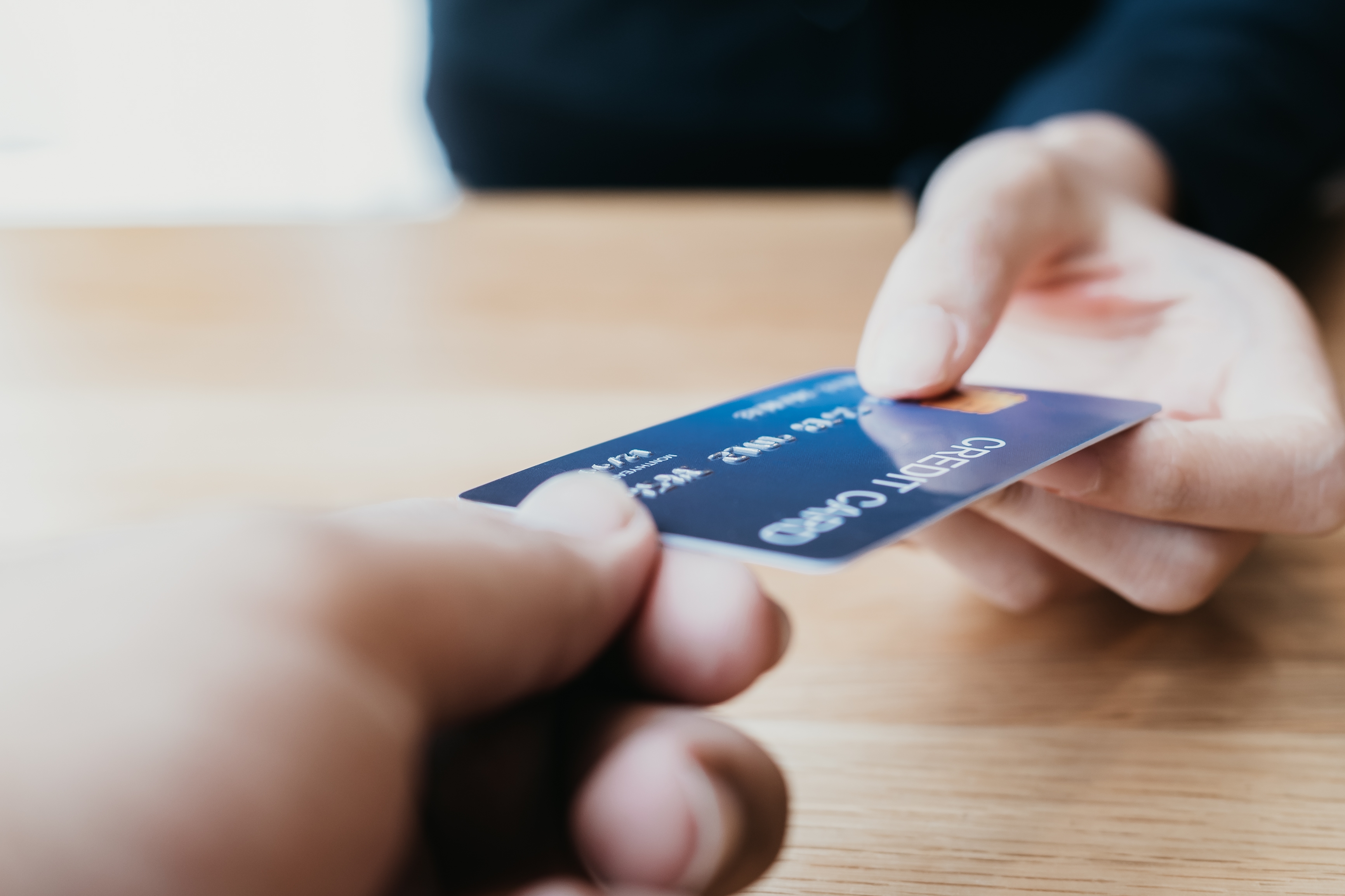 A person handing over a credit card | Source: Shutterstock