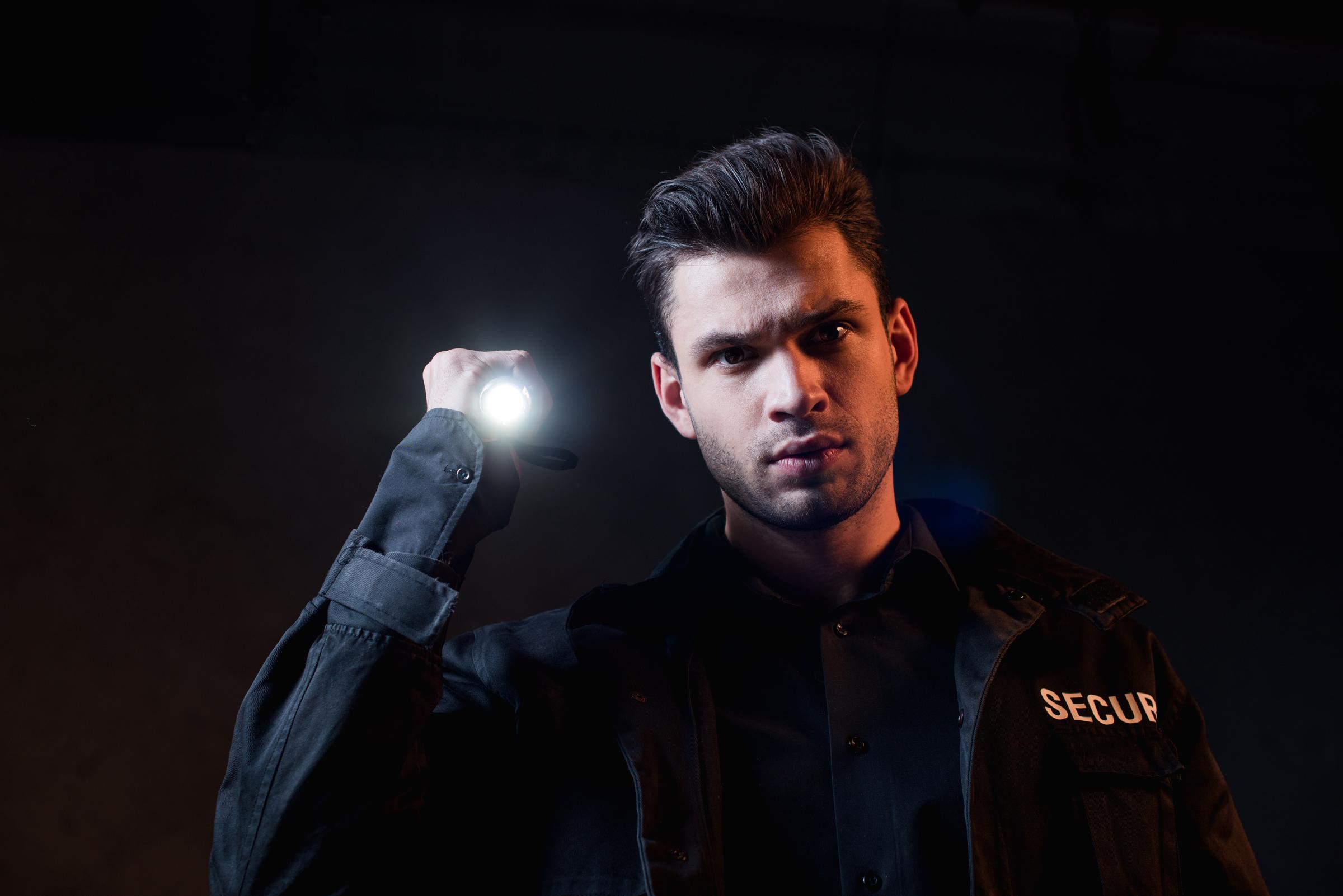 Security guard holding a flashlight | Source: Shutterstock