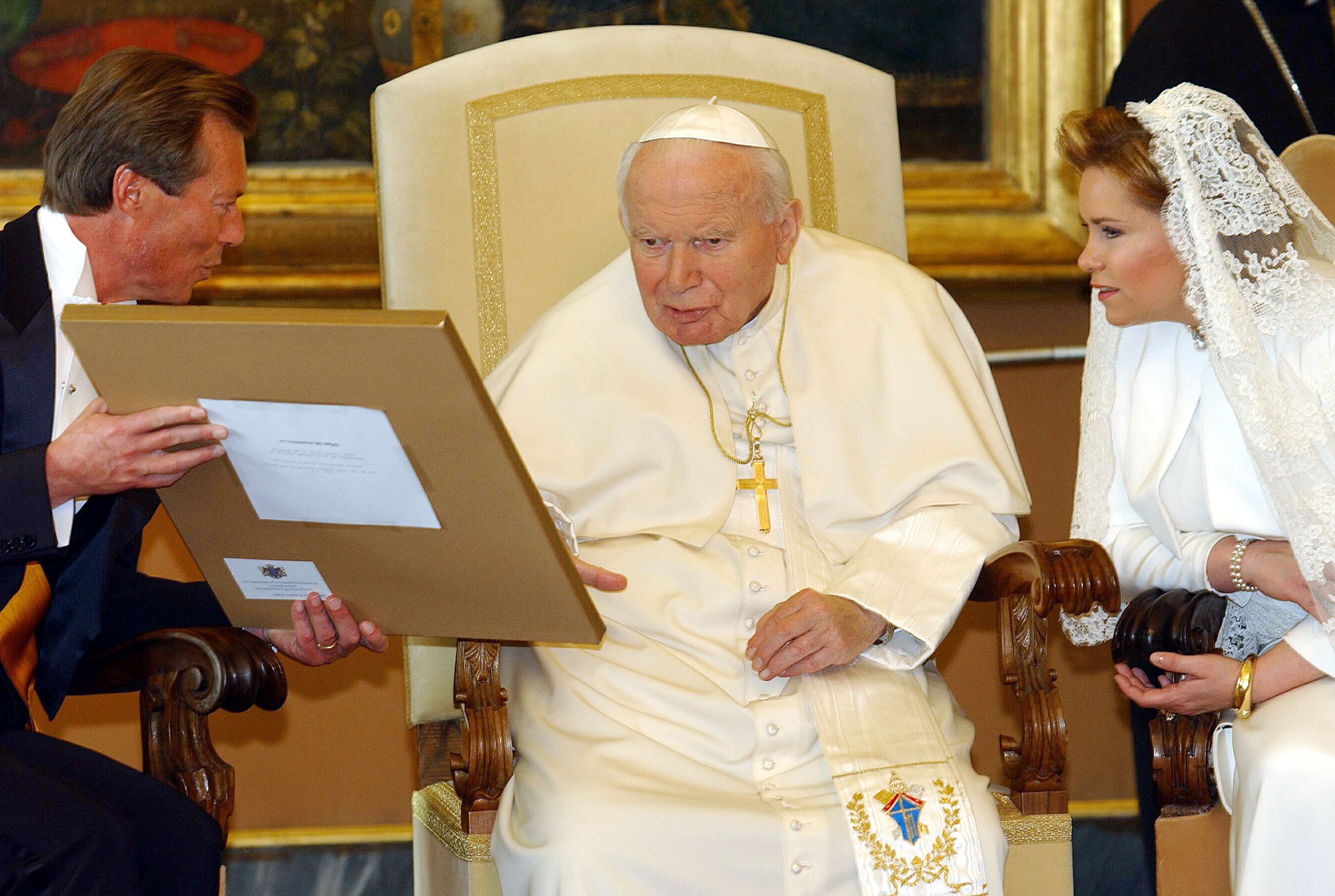 Pope John Paul II (C) receives a gift from Luxembourg's Grand Duke Henri (L) and Grand Duchess Maria Teresa on March 27, 2003 in Vatican City | Source: Getty Images