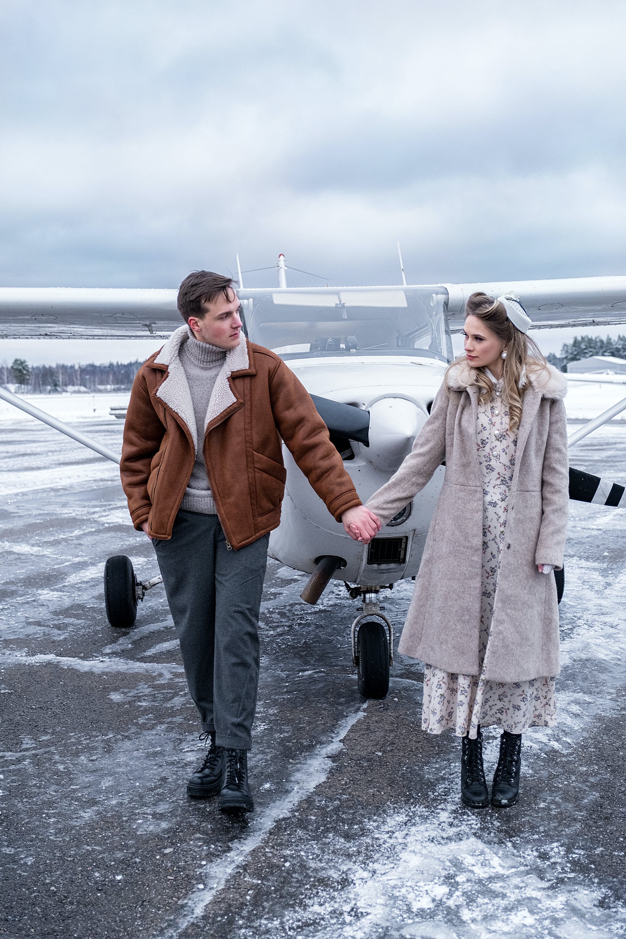 A young couple holding hands at an airfield | Source: Pexels