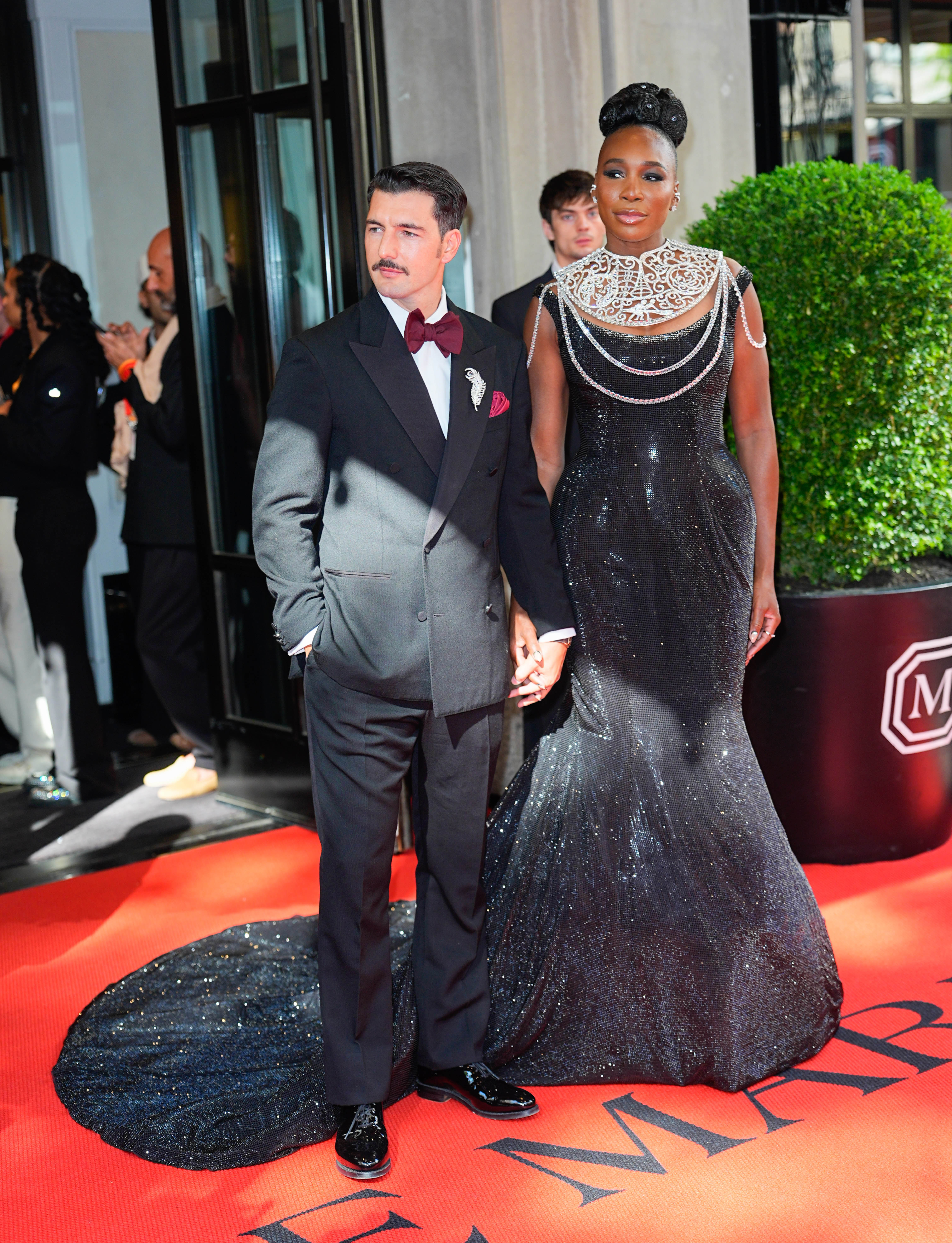 Alex Preti and Venus Williams depart their hotel for the event, holding hands as Williams showcases her black sequined gown and ornate silver neckline on the red carpet.