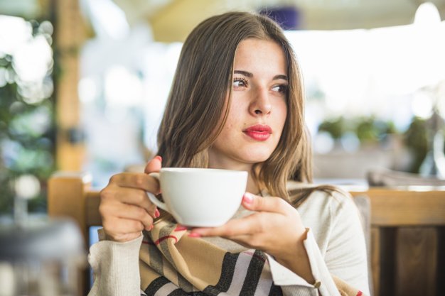 Une femme tenant une tasse. | Photo: Freepik