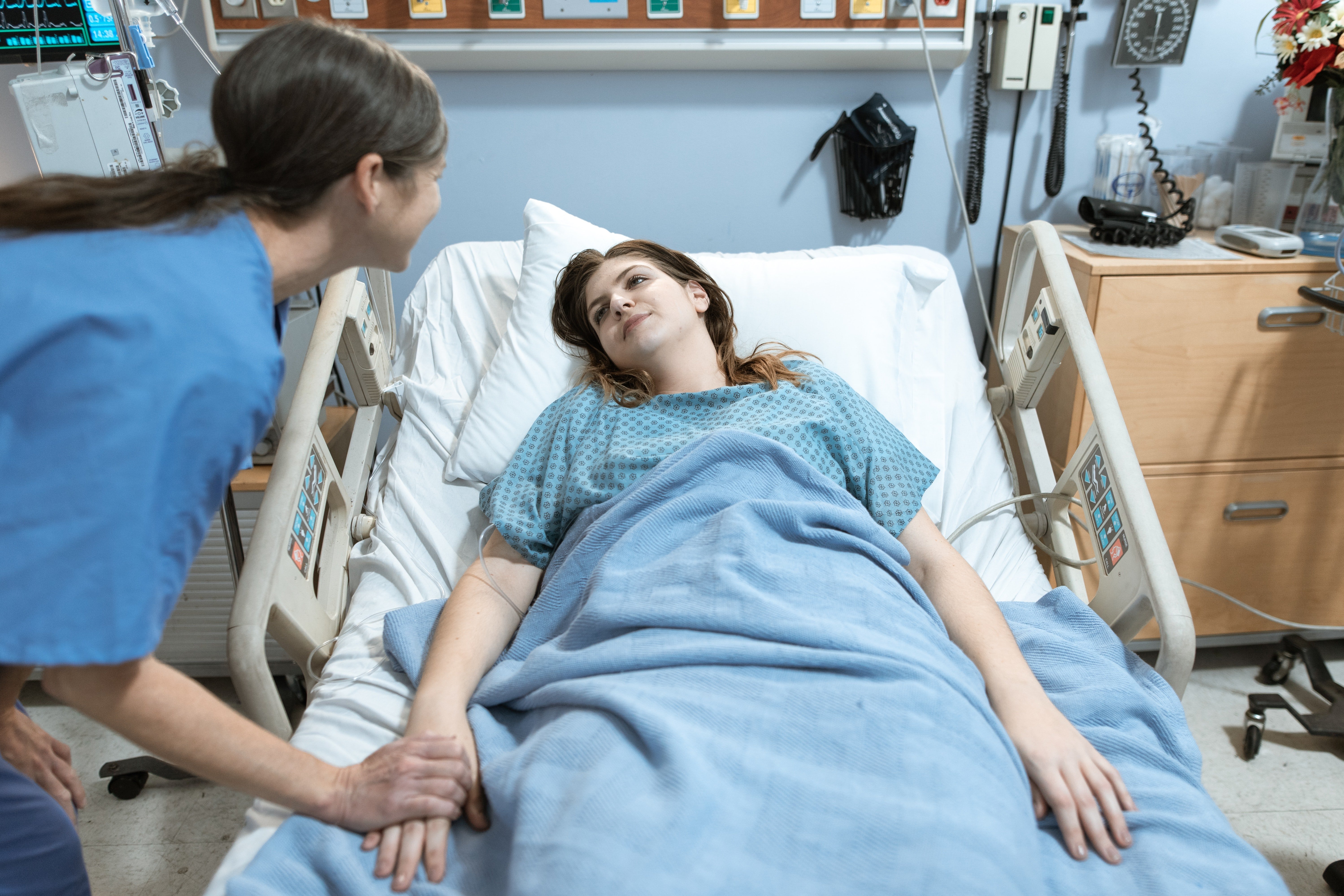 Doctora atendiendo a una paciente en una cama. | Foto: Pexels