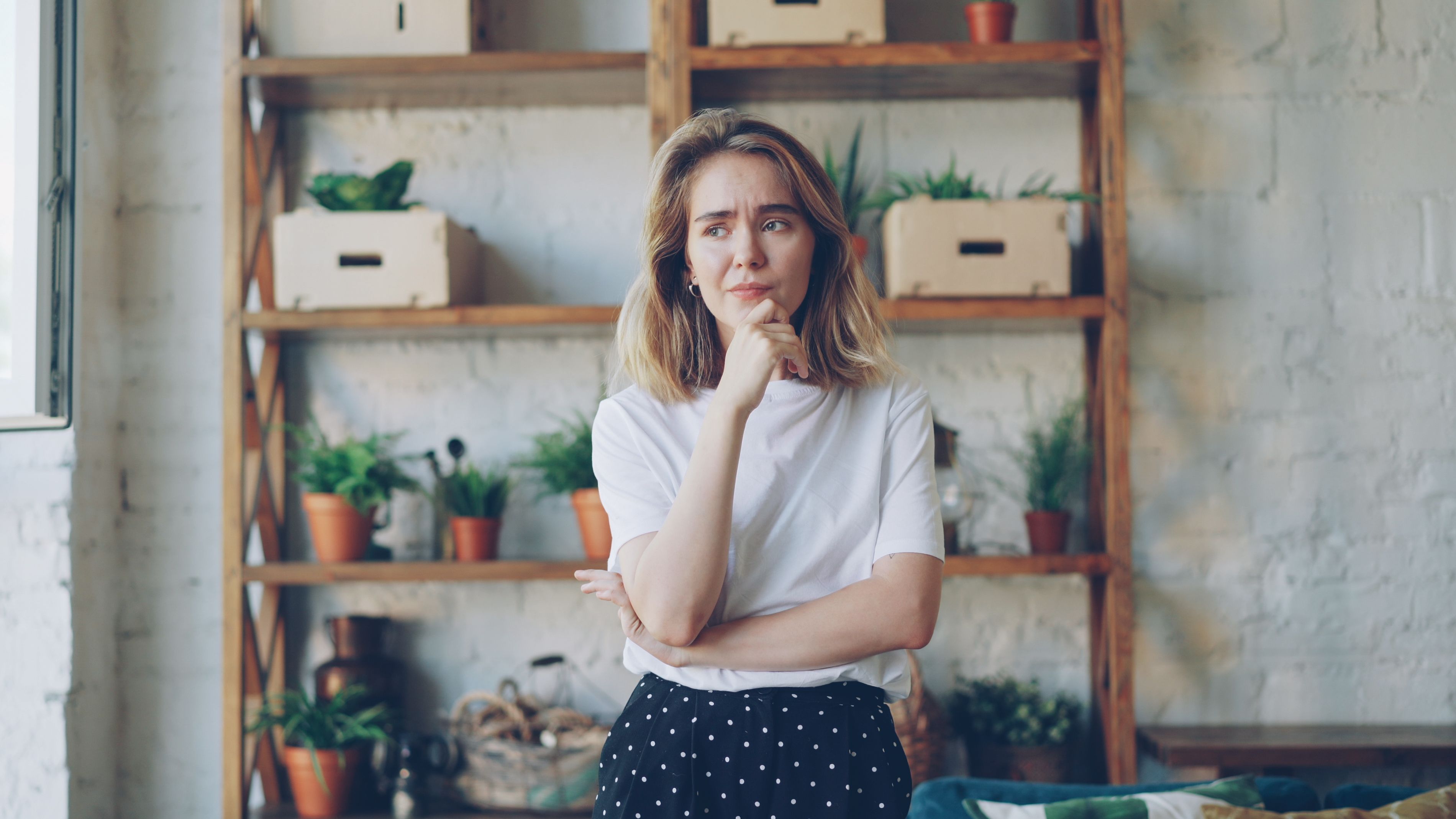 Person appearing hesitant as she stands in front of a cluttered shelf | Source: Pexels
