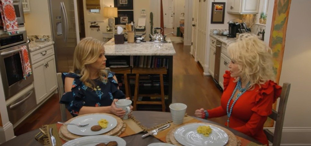 Dolly Parton and Reese Witherspoon discussing at Dolly Patron’s kitchen | Source: YouTube/Reese Witherspoon x Hello Sunshine