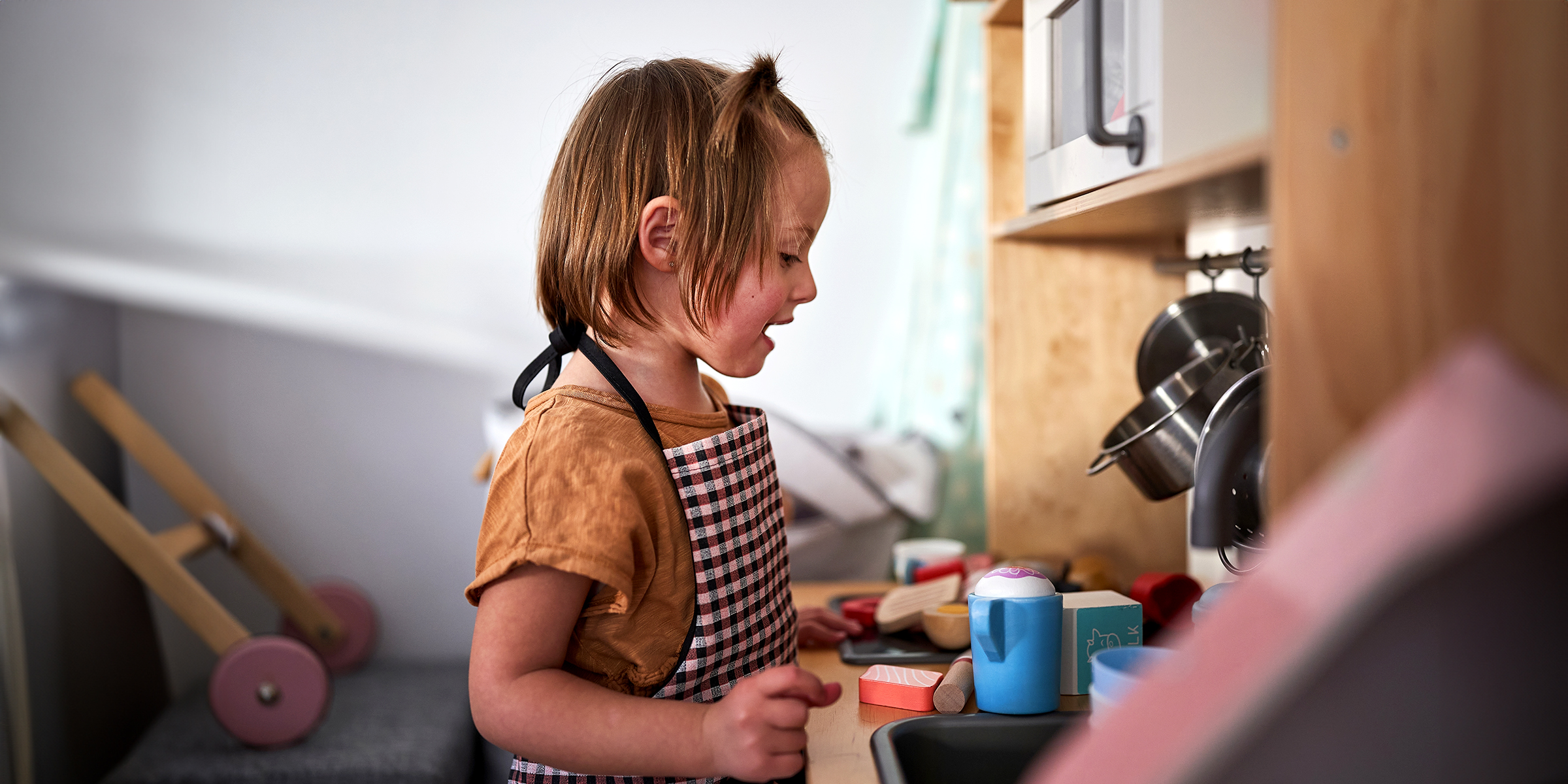 A little girl playing with her mini kitchen set | Source: Shutterstock