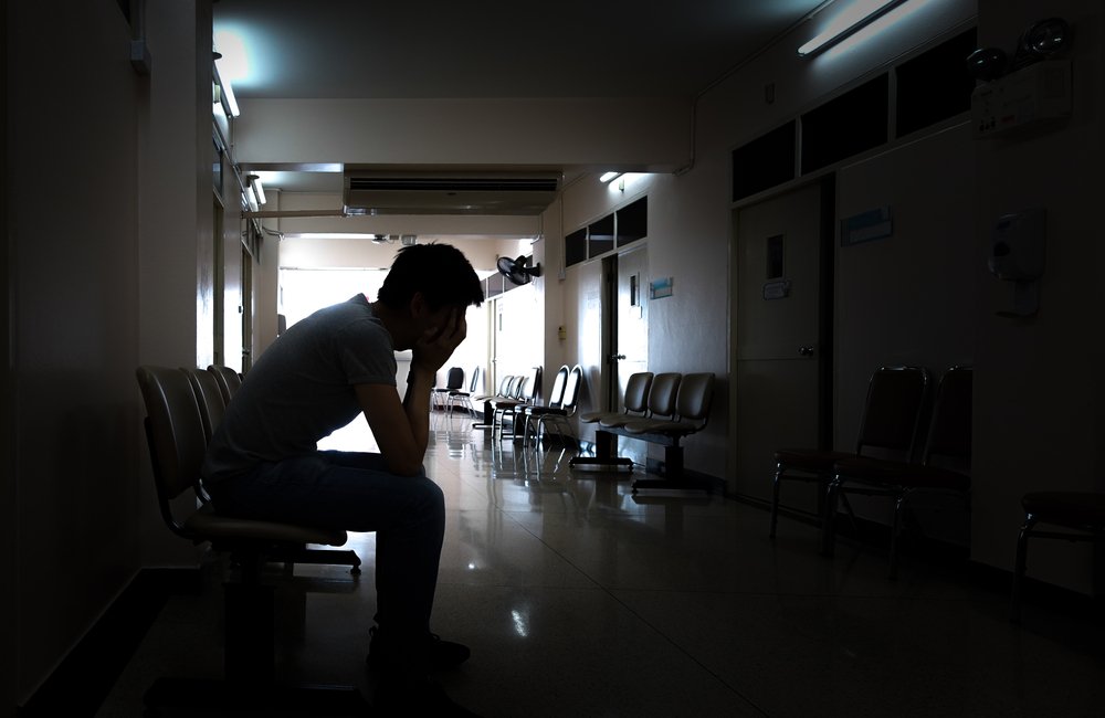 A silhouette of a crying man waiting in the hospital after an emergency | Photo: Shutterstock/iphotosmile