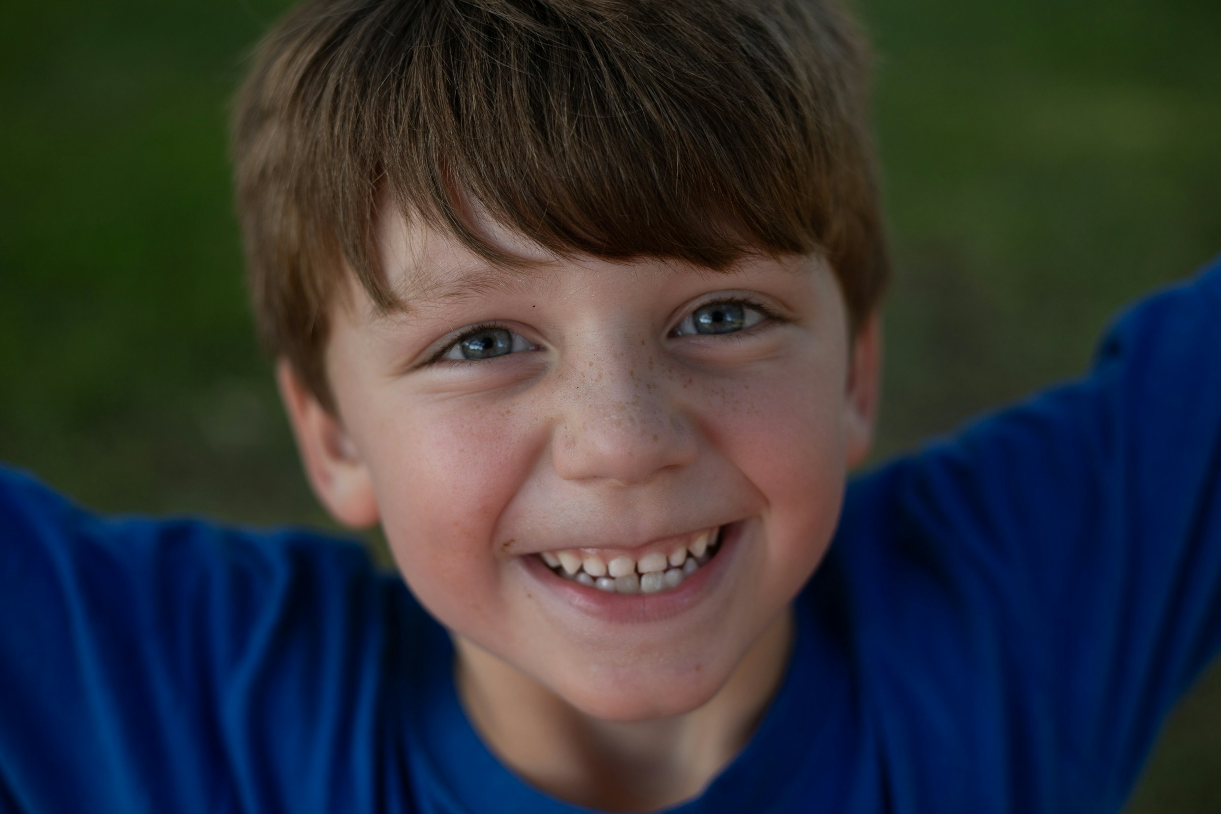 A smiling little boy in a blue shirt | Source: Unsplash