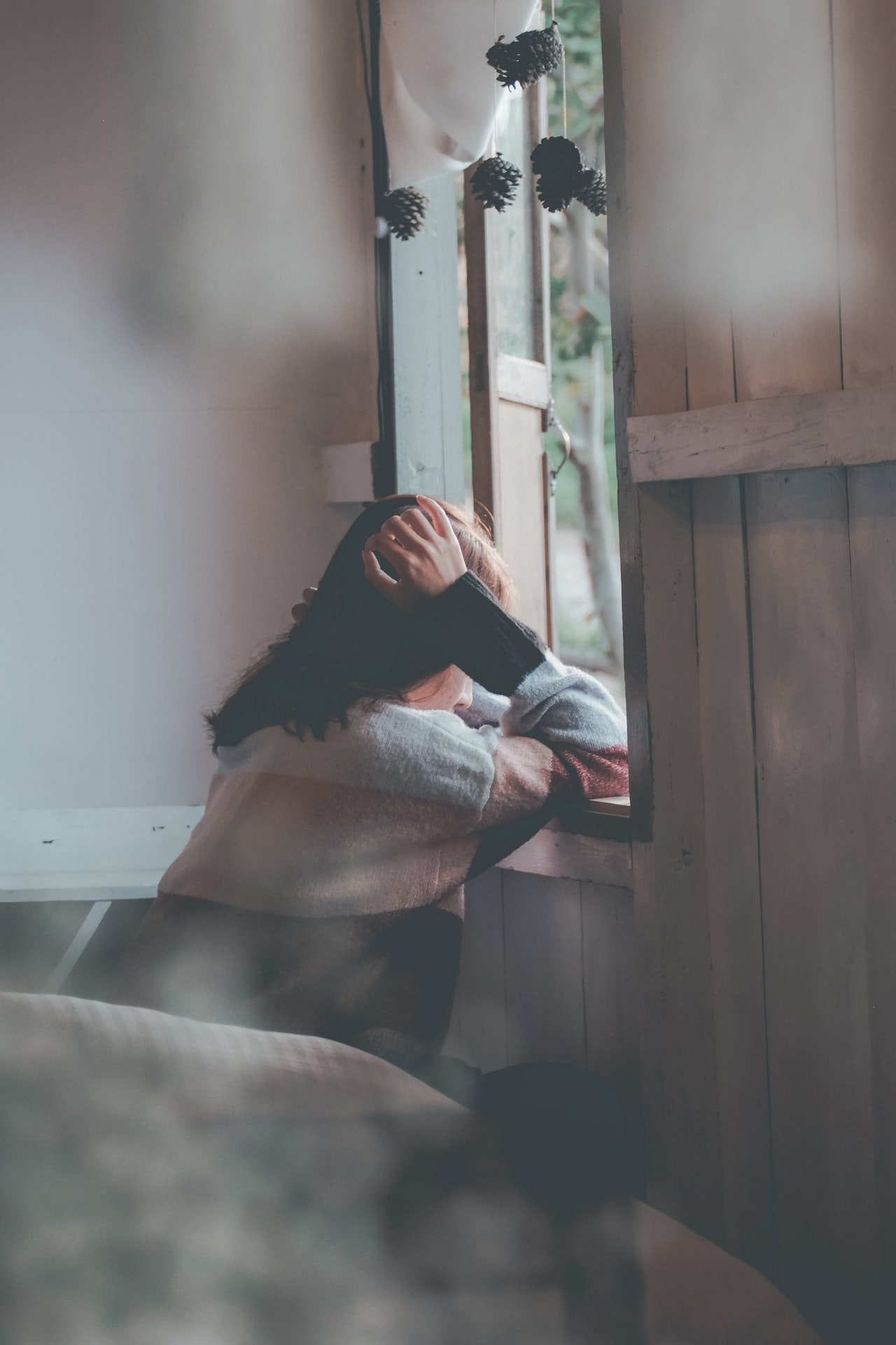Sad woman looking out the window | Photo: Pexels