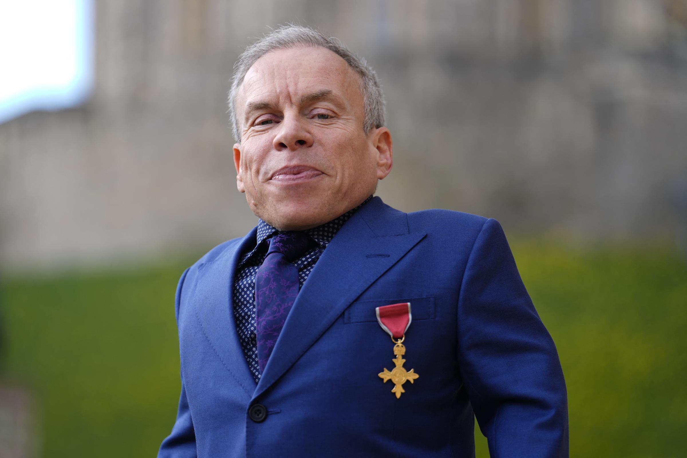 Warwick Davis poses with their medal after being appointed an Officer of the Order of the British Empire (OBE) following an investiture ceremony at Windsor Castle on 11 March 2026. | Source: Getty Images