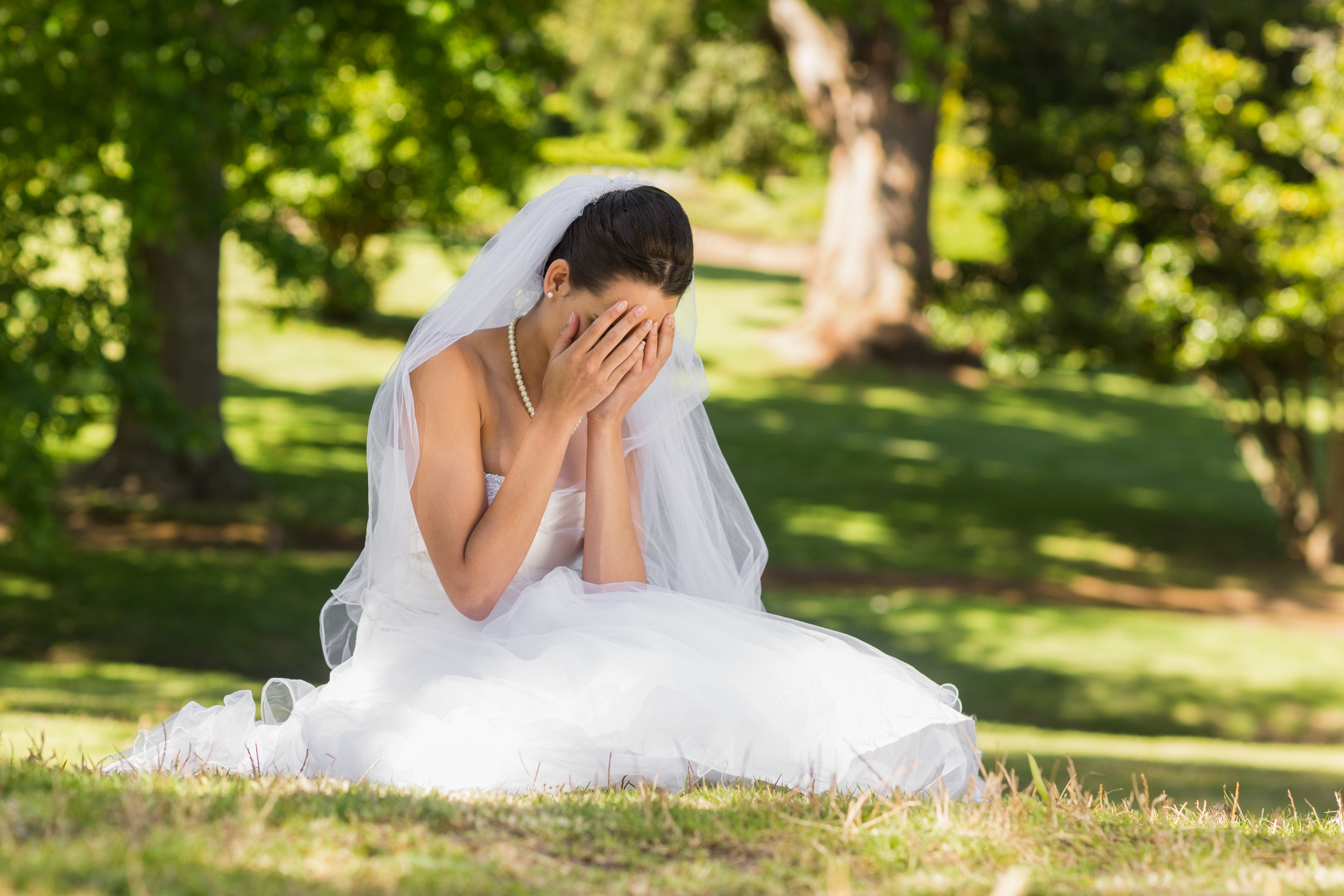 A bride crying in a park | Source: Shutterstock