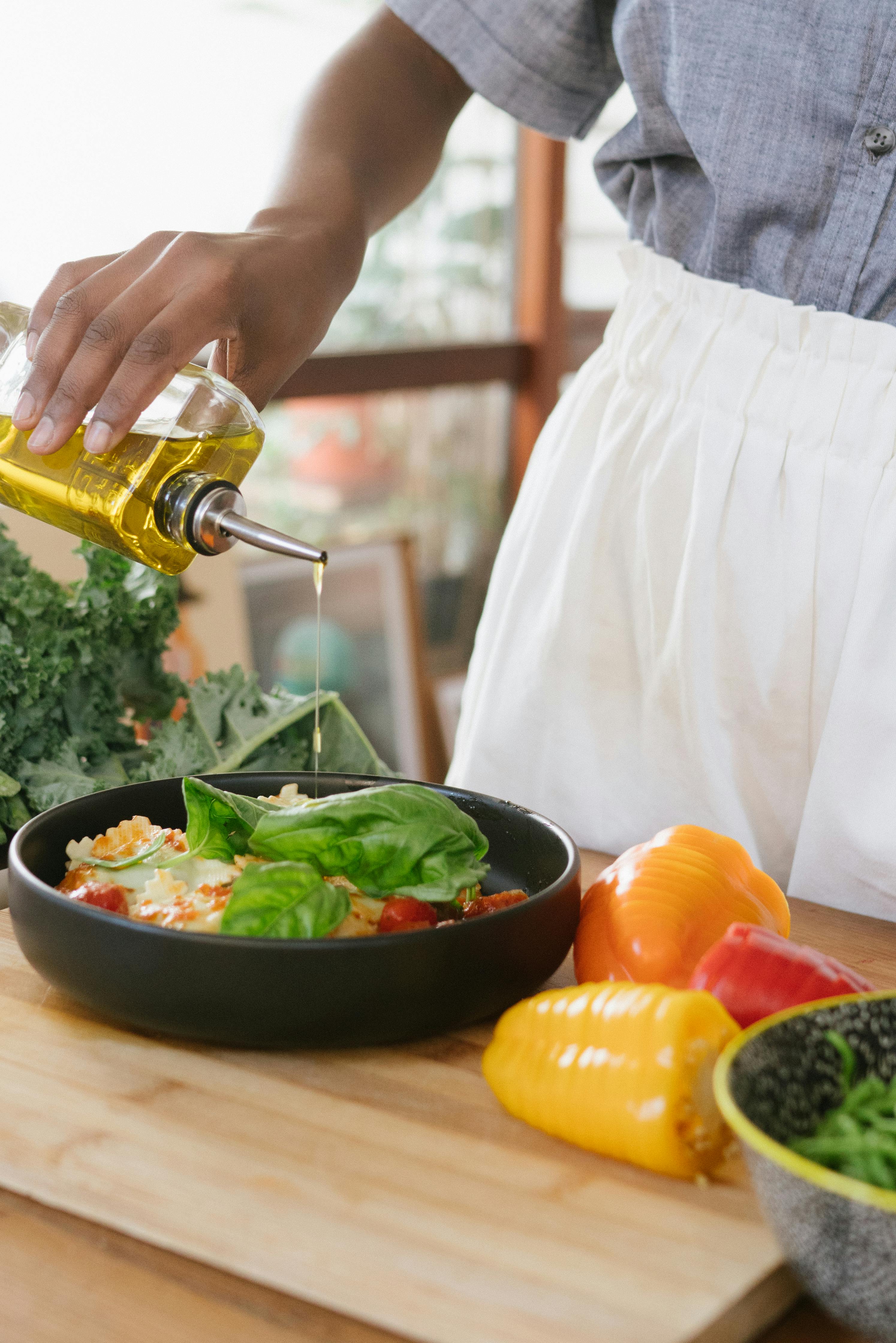 A woman preparing food with olive oil | Source: Pexels
