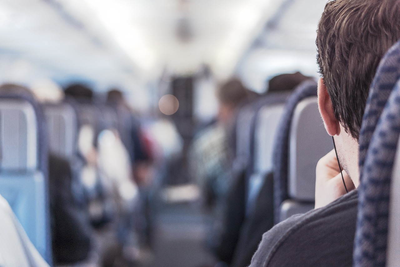 Close-up rear view of a man sitting in an airplane | Source: Pixabay