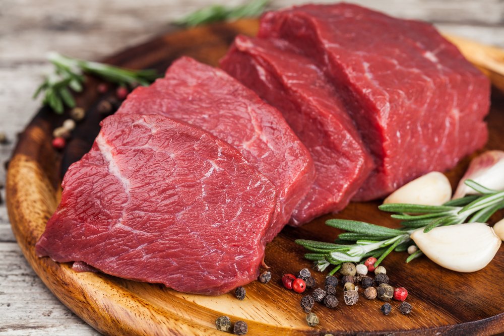 Viande de bœuf crue sur une planche à découper. | Shutterstock